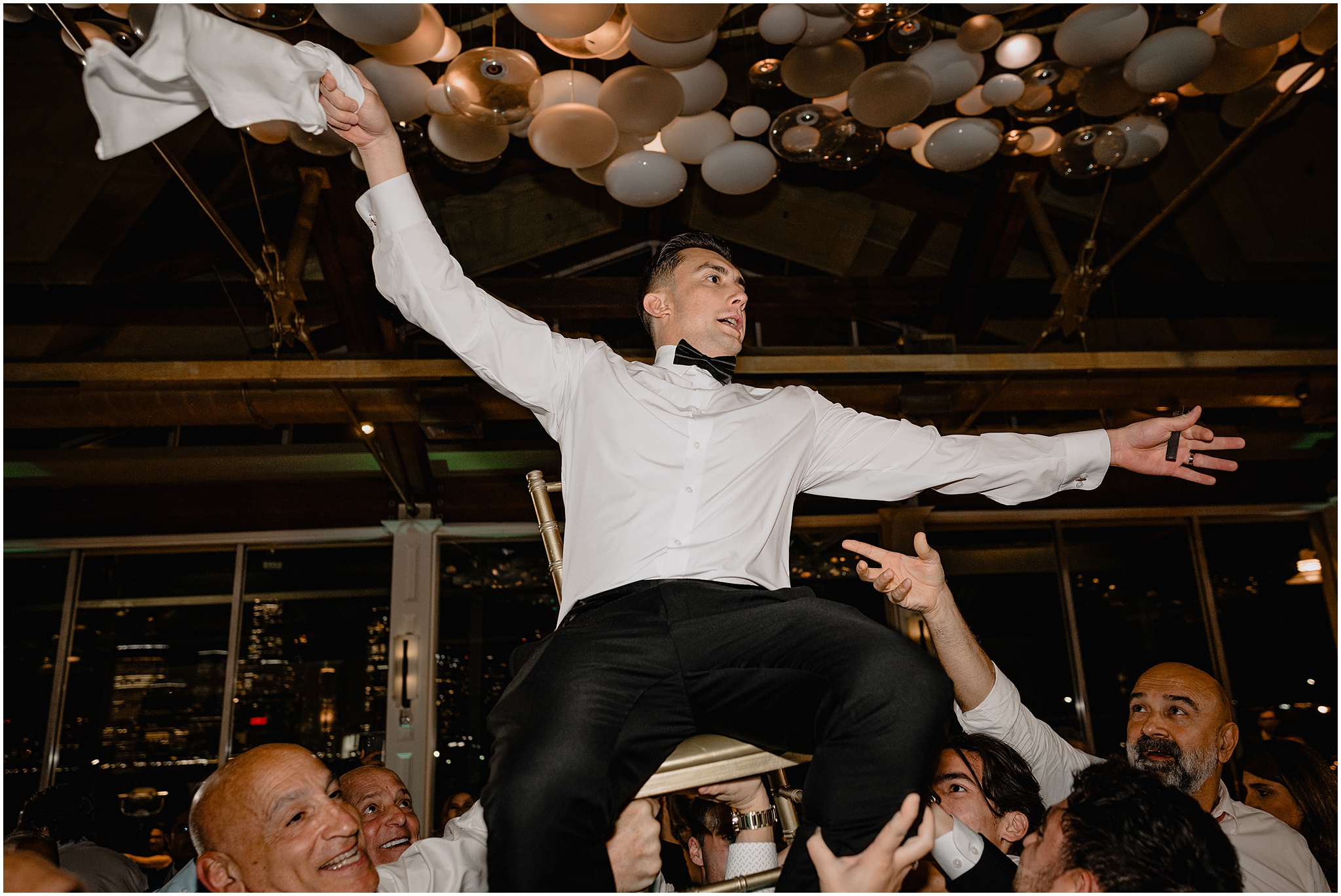guests lift up groom during wedding reception at the Liberty House