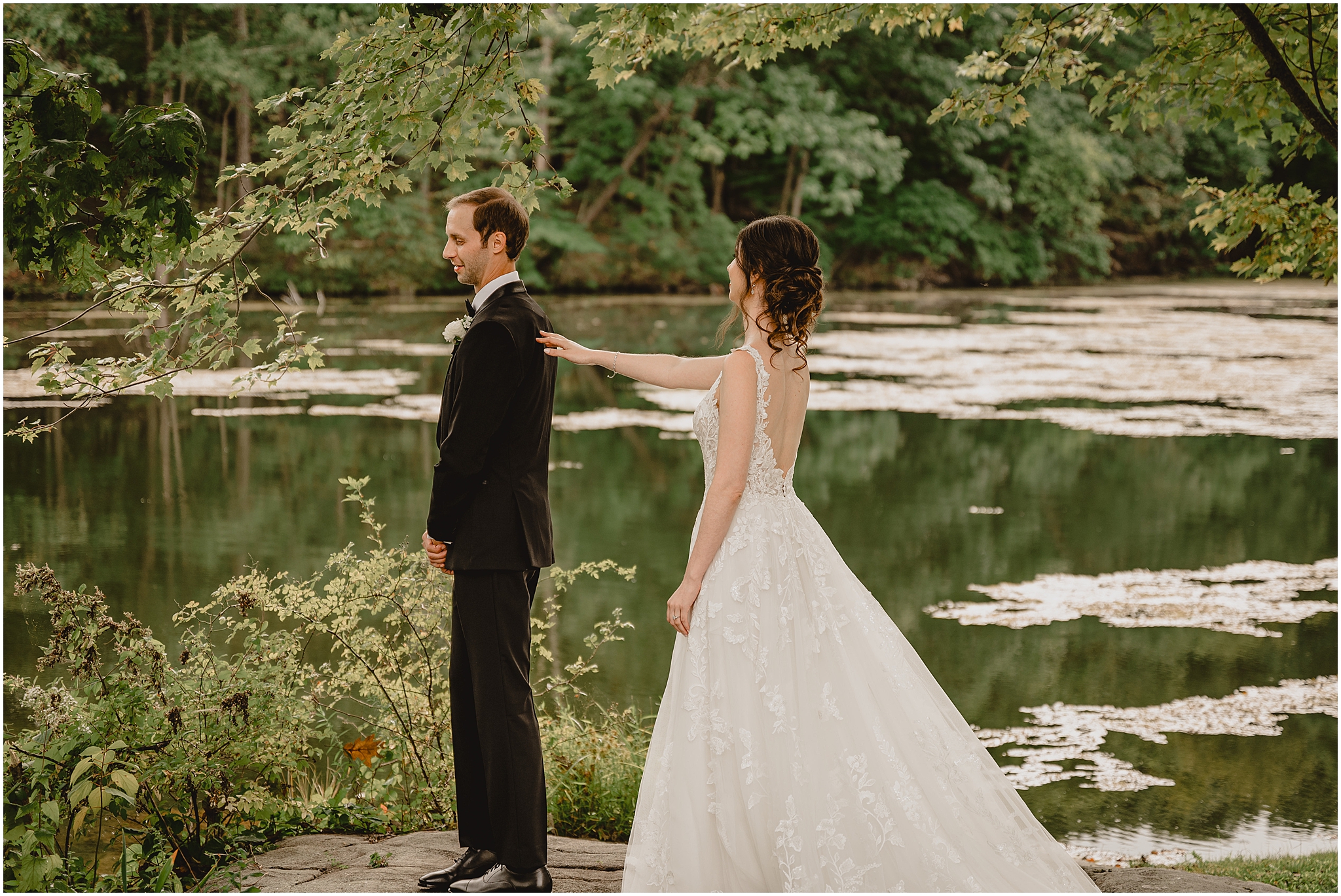 bride reaches for groom during first look near the pond at the Reserve at Perona Farms
