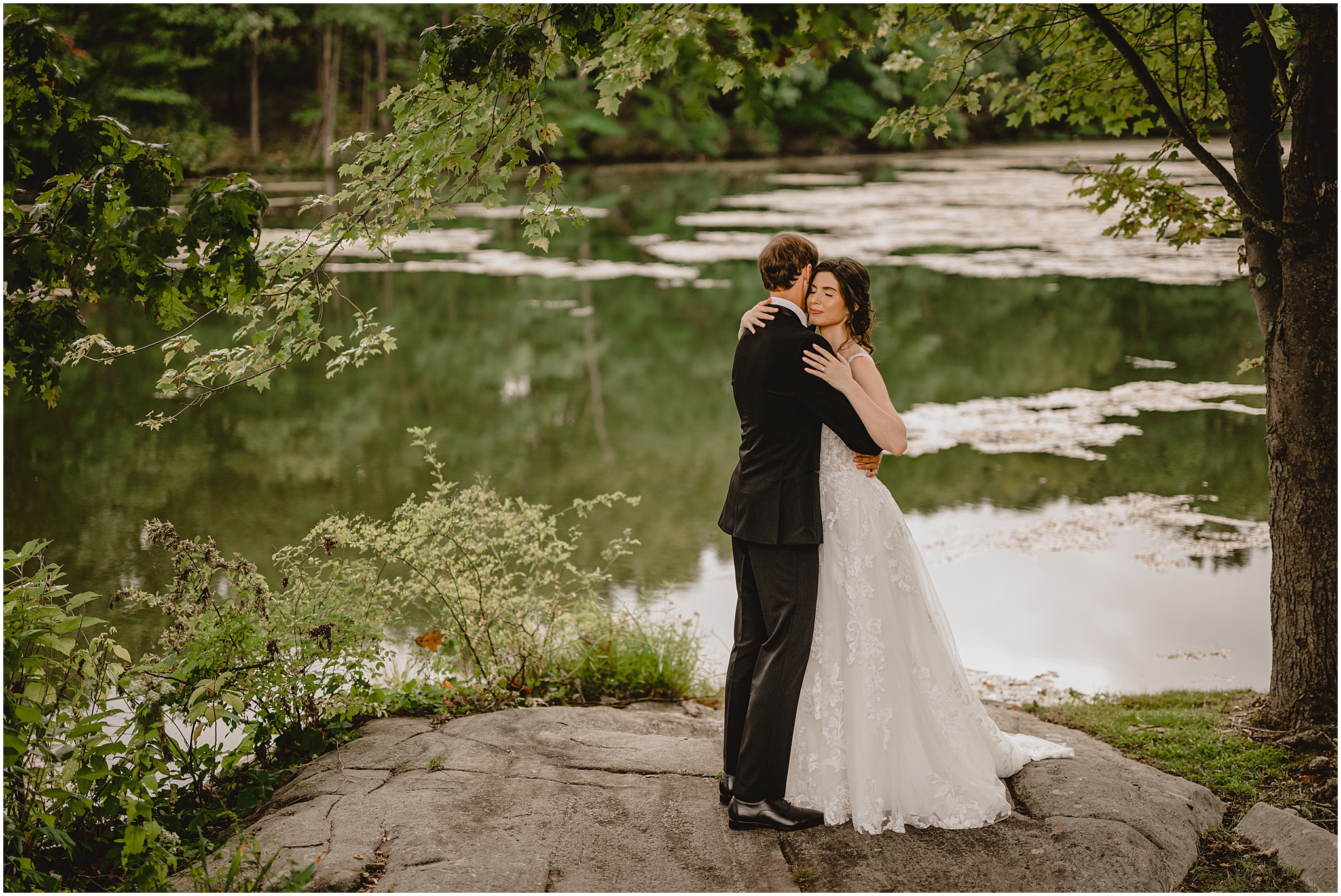 bride and groom hg on flat rock b the pond at the Reserve at Perona Farms