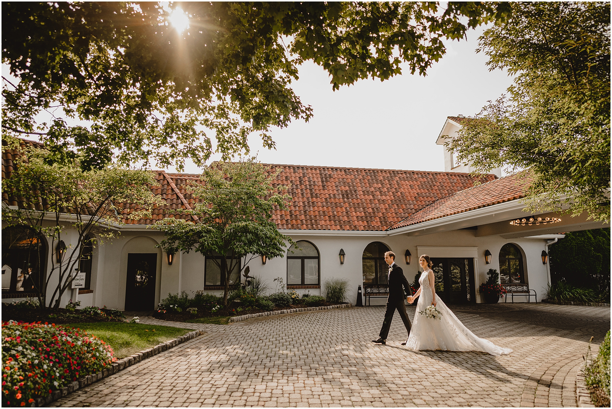 newlyweds hold hands walking across brick patio at the Reserve at Perona Farms