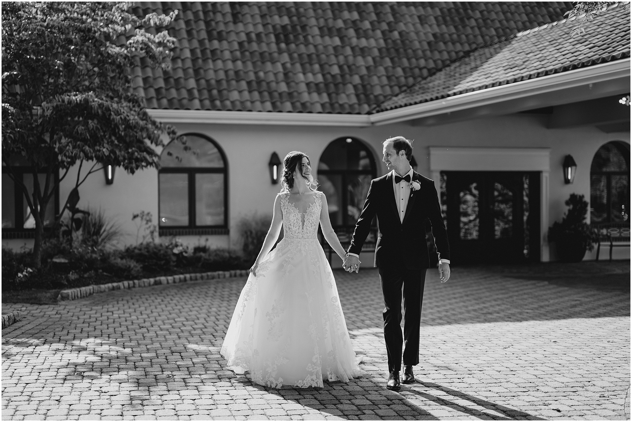 bride and groom hold hands walking away from front entrance at the Reserve at Perona Farms