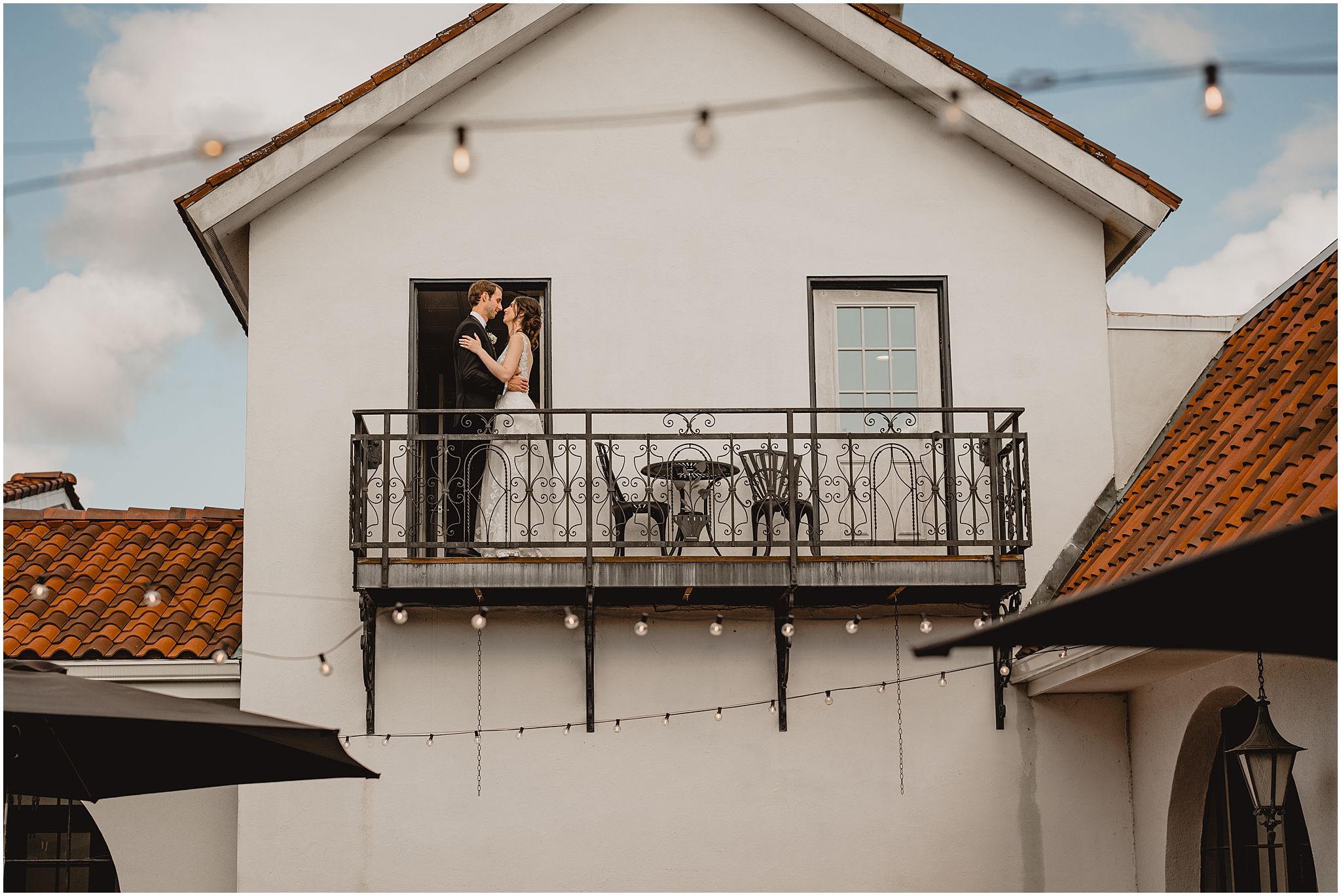 bride and groom hug on balcony of the Reserve at Perona Farms