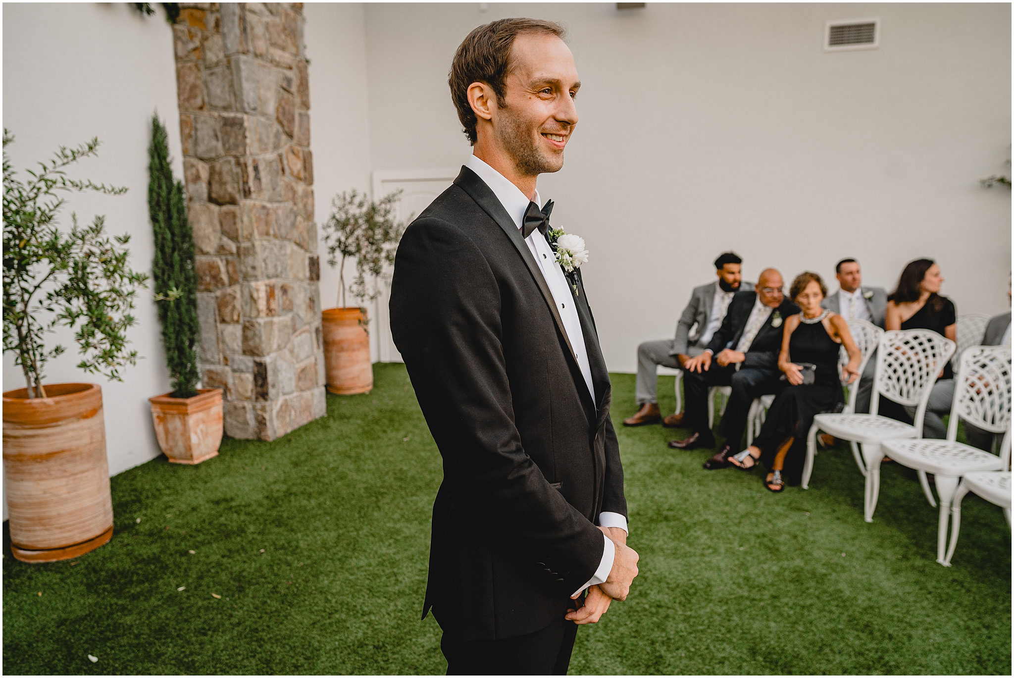 groom smiles watching wedding ceremony at the Reserve at Perona Farms