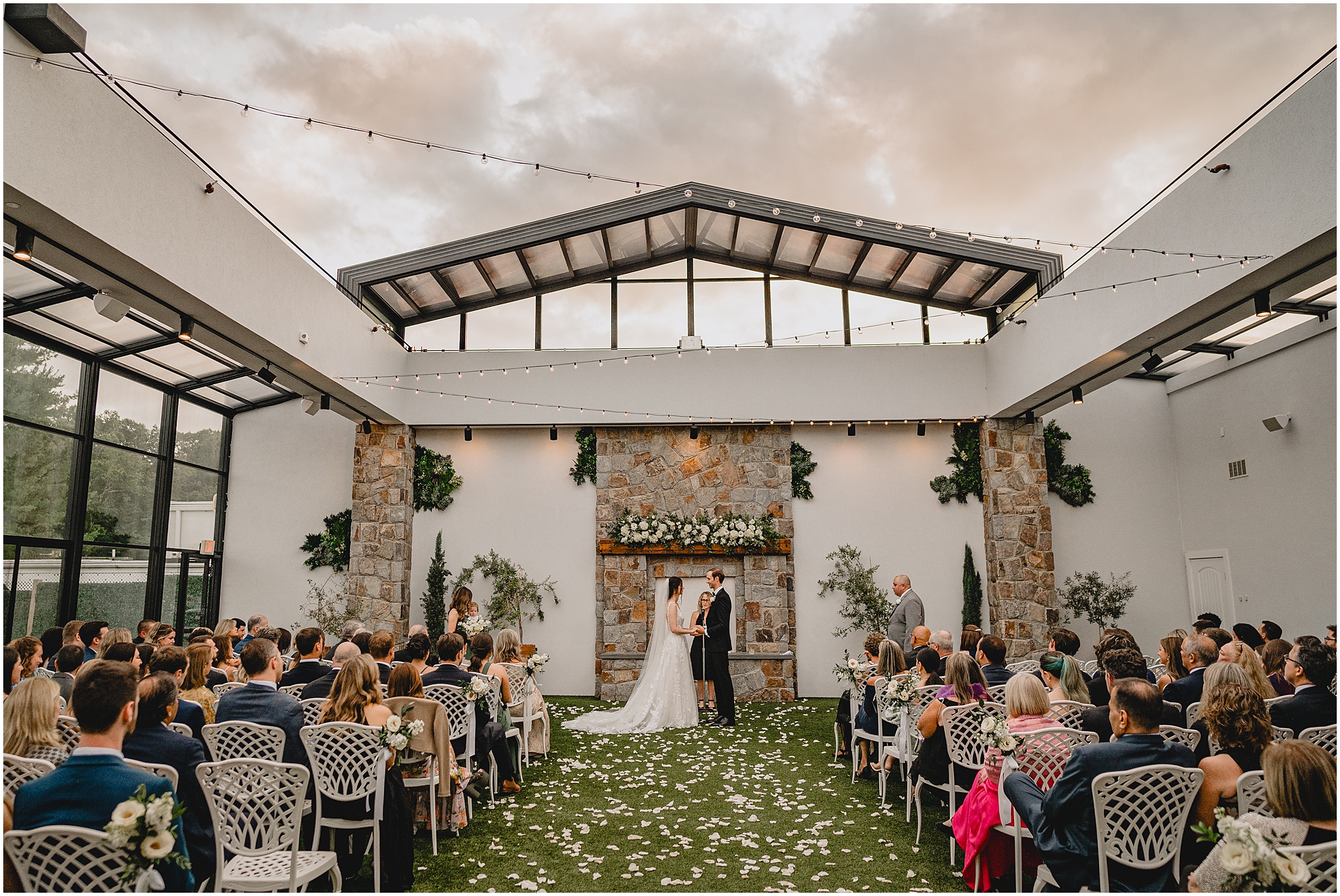 bride and groom hold hands under cloudy sky during wedding ceremony in the open-air atrium at the Reserve at Perona Farms
