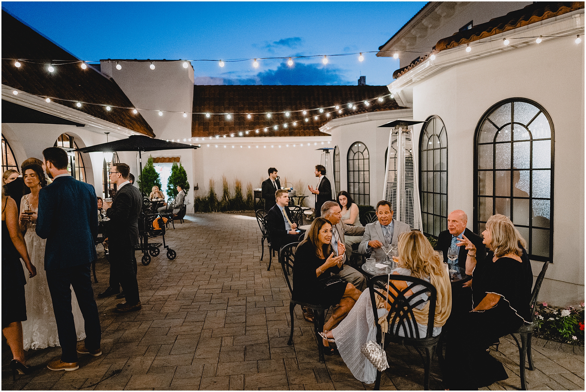 guests sit and eat and mingle on patio at the Reserve at Perona Farms