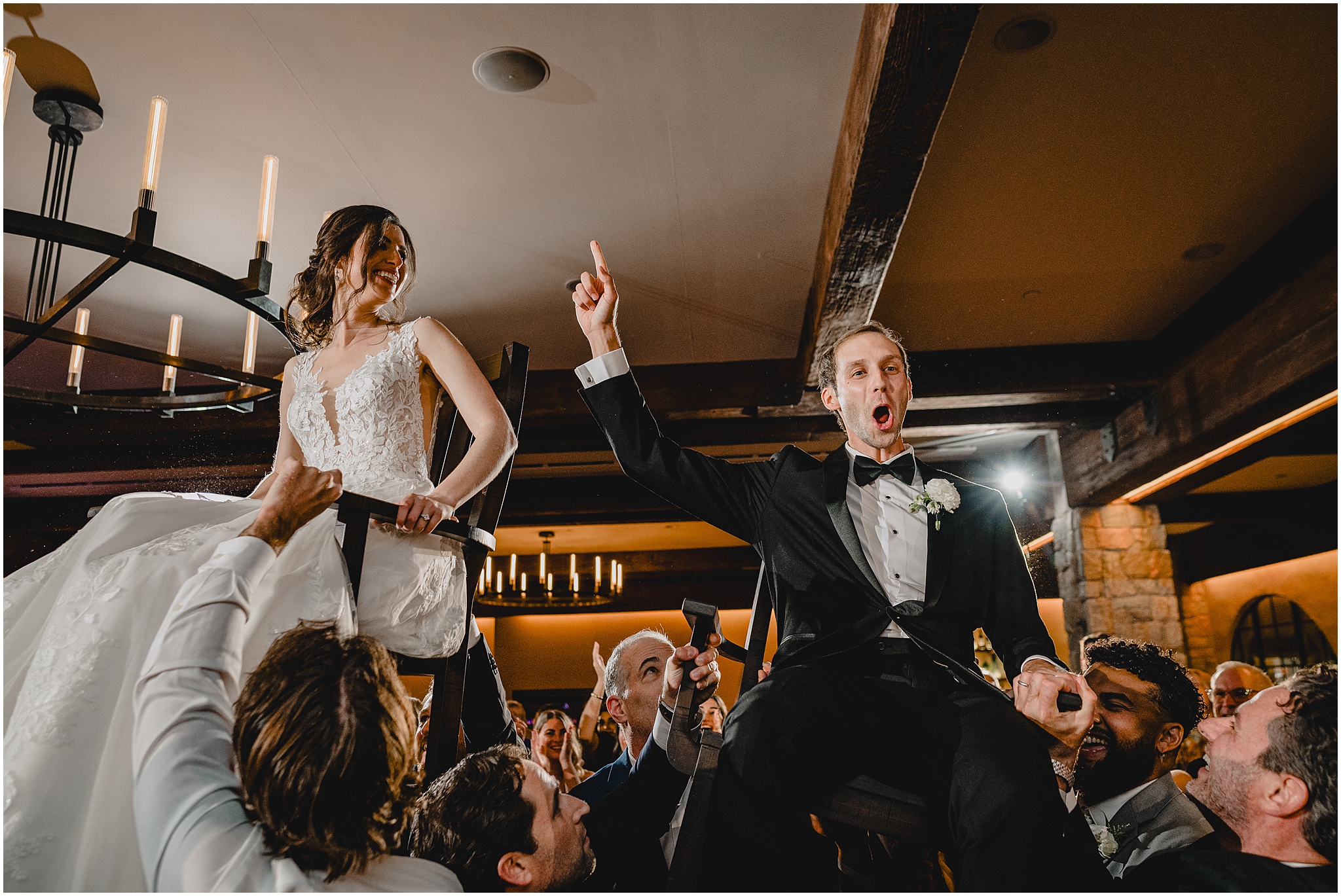 groom cheers while groomsmen lift him up during hora 