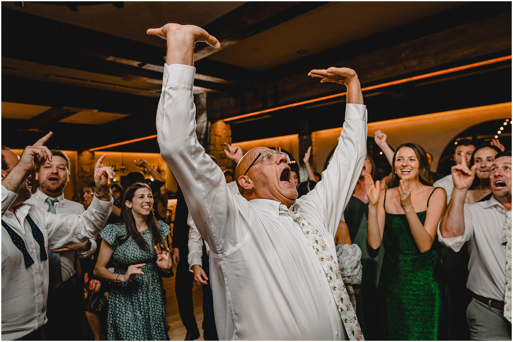 older man laughs on dance floor with hands in the air during reception in New Jersey 
