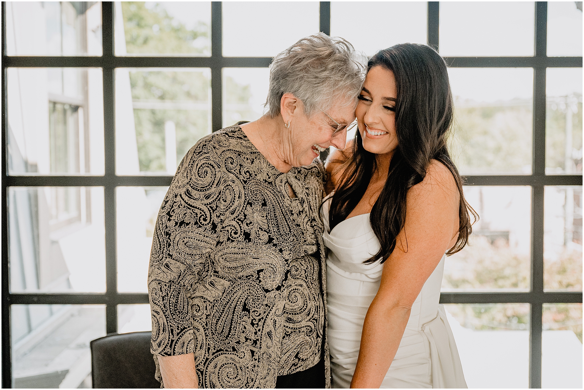 bride and grandmother hug together during first look
