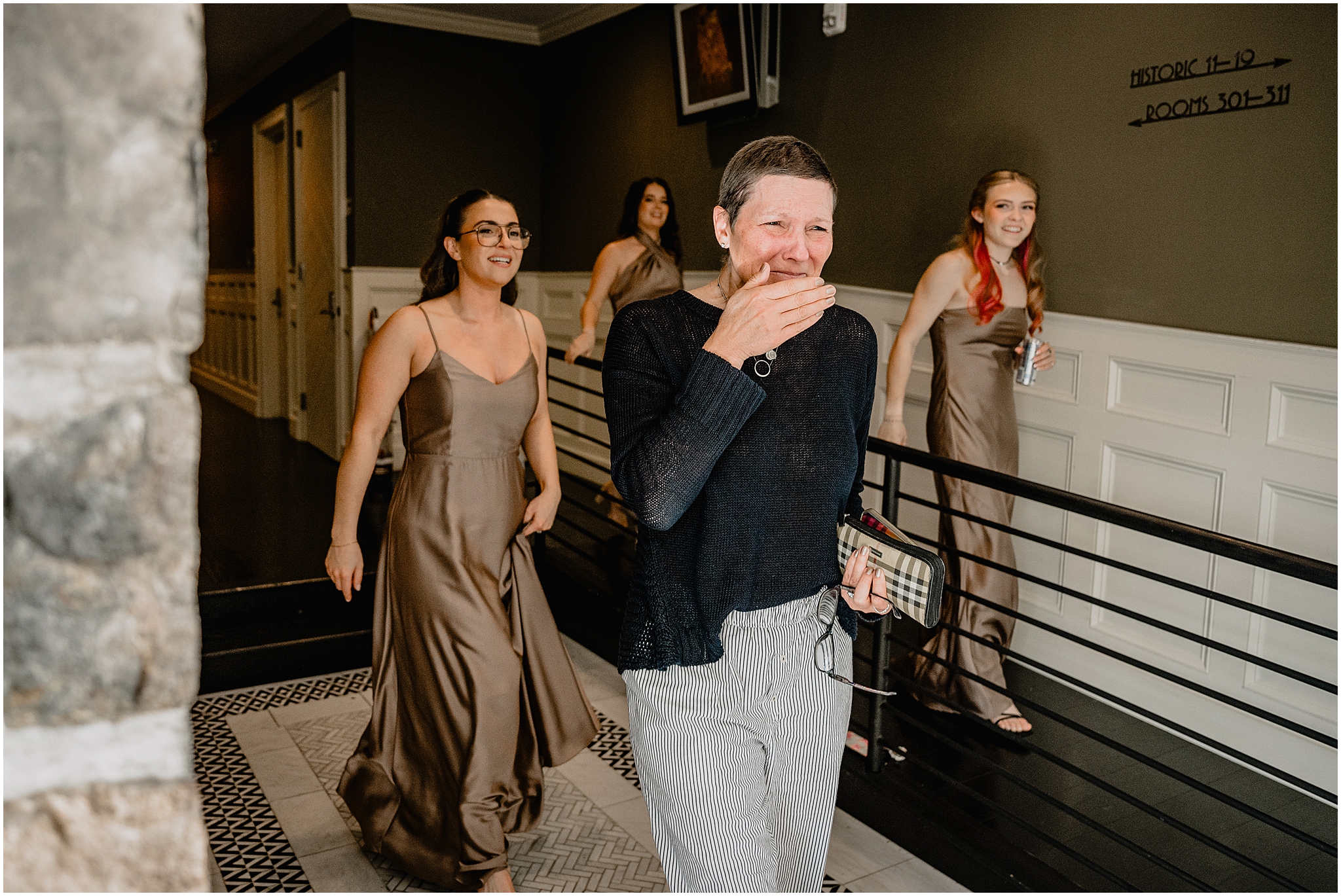 woman cries when looking at bride with bridesmaids behind her
