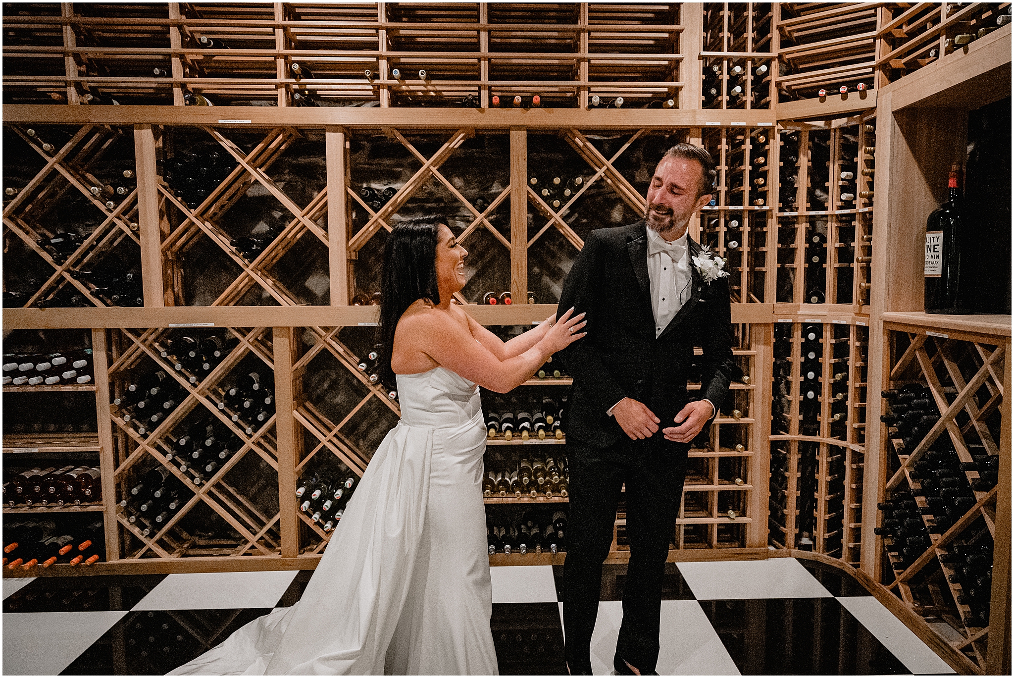 groom turns to look at bride in The Logan Inn wine cellar