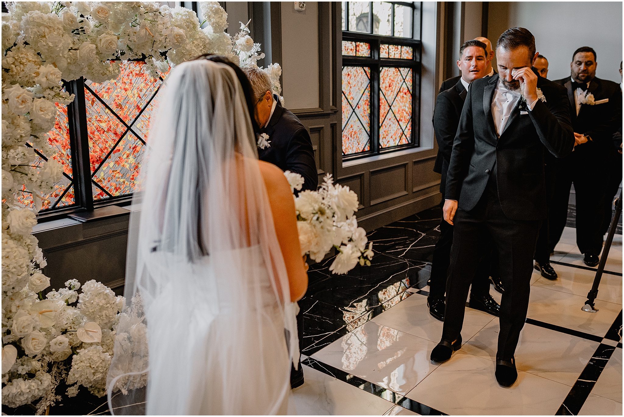 groom cries looking at bride during wedding ceremony inside The Logan Inn
