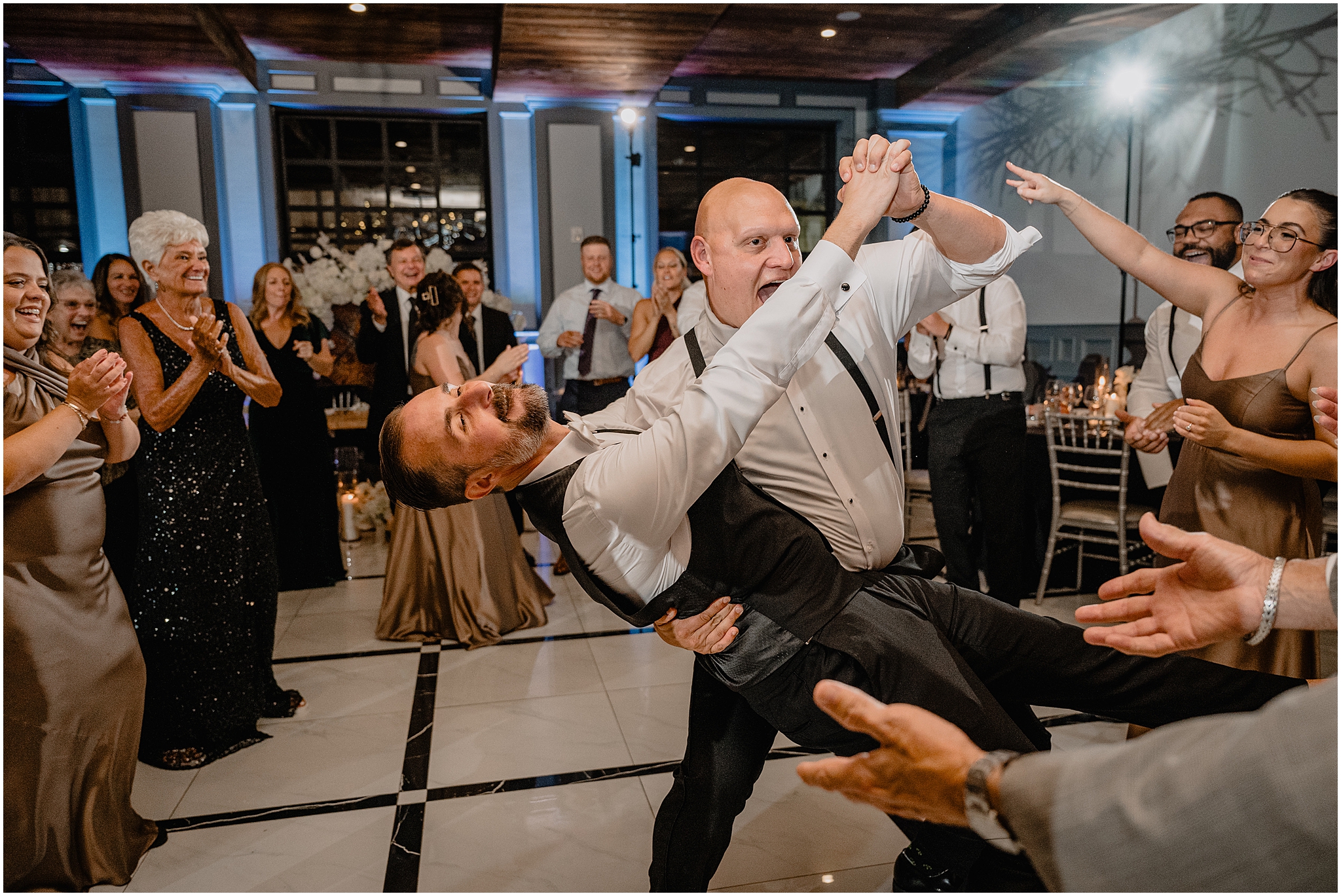 guest dips groom laughing during wedding reception in New Hope PA
