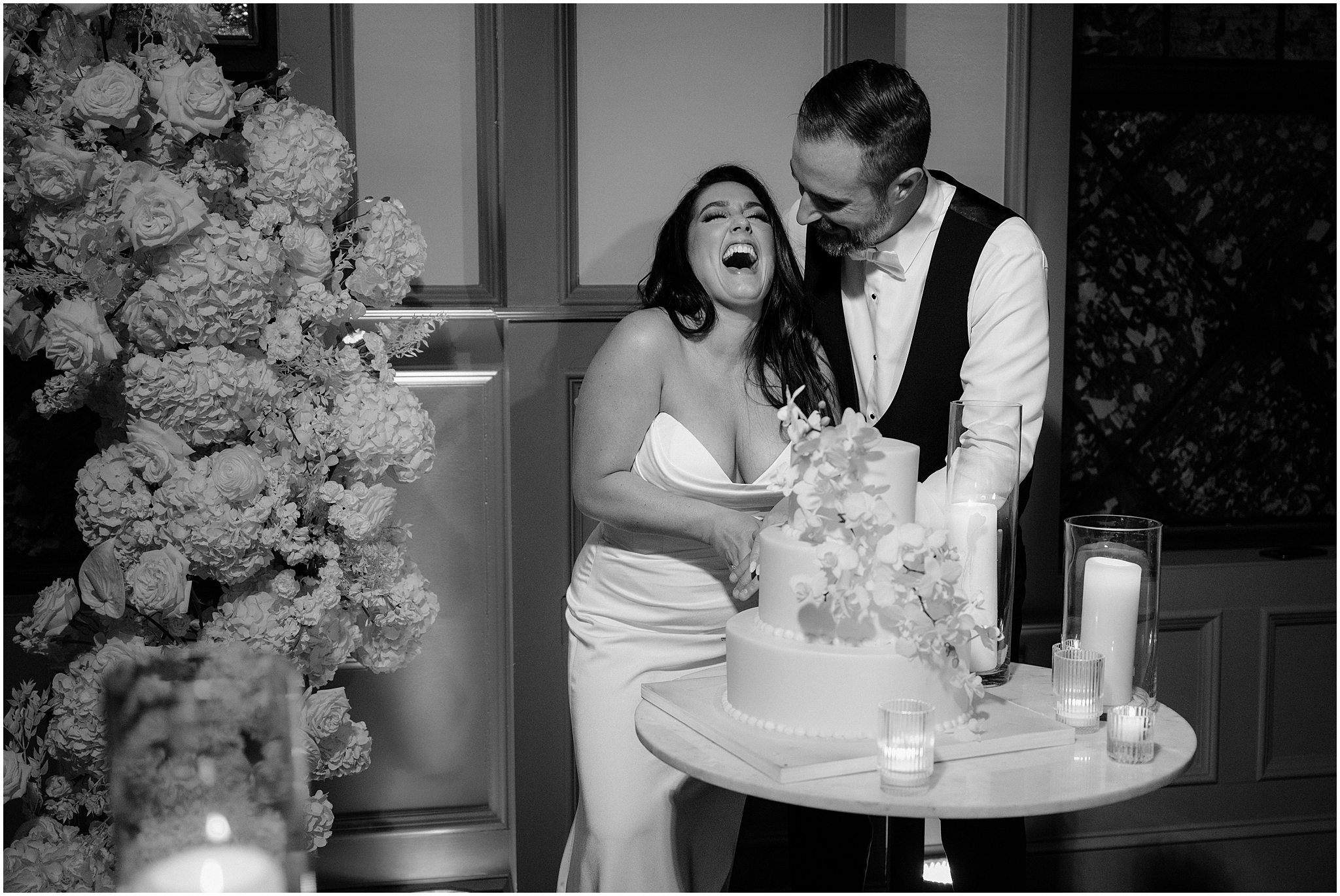 bride and groom laugh cutting wedding cake at wedding reception in New Hope PA