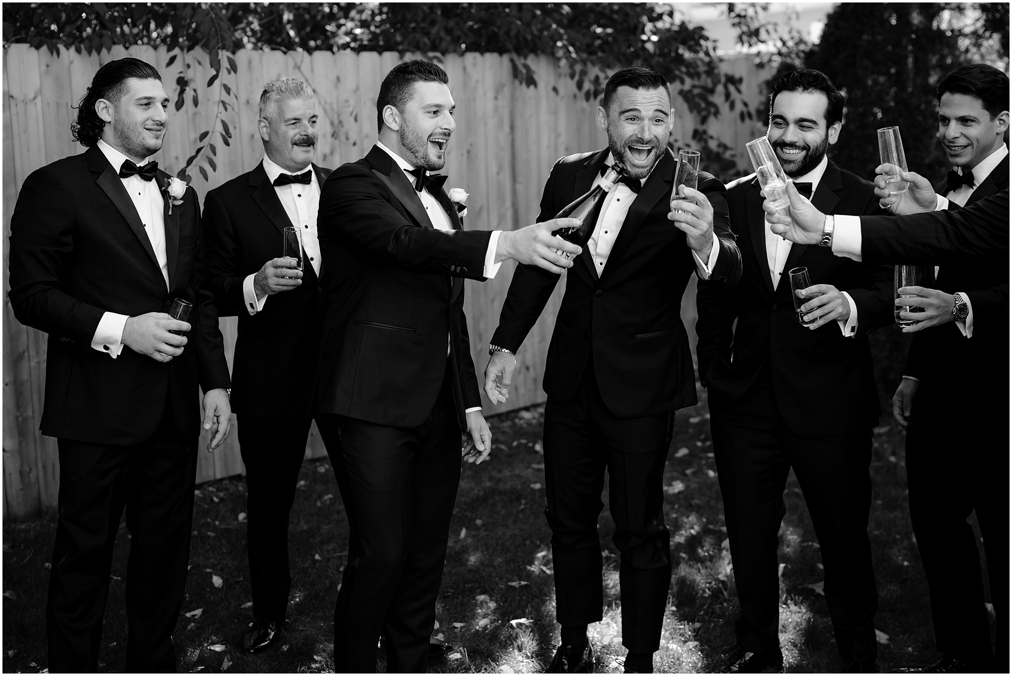 groom and groomsmen toast in lawn of Long Island home