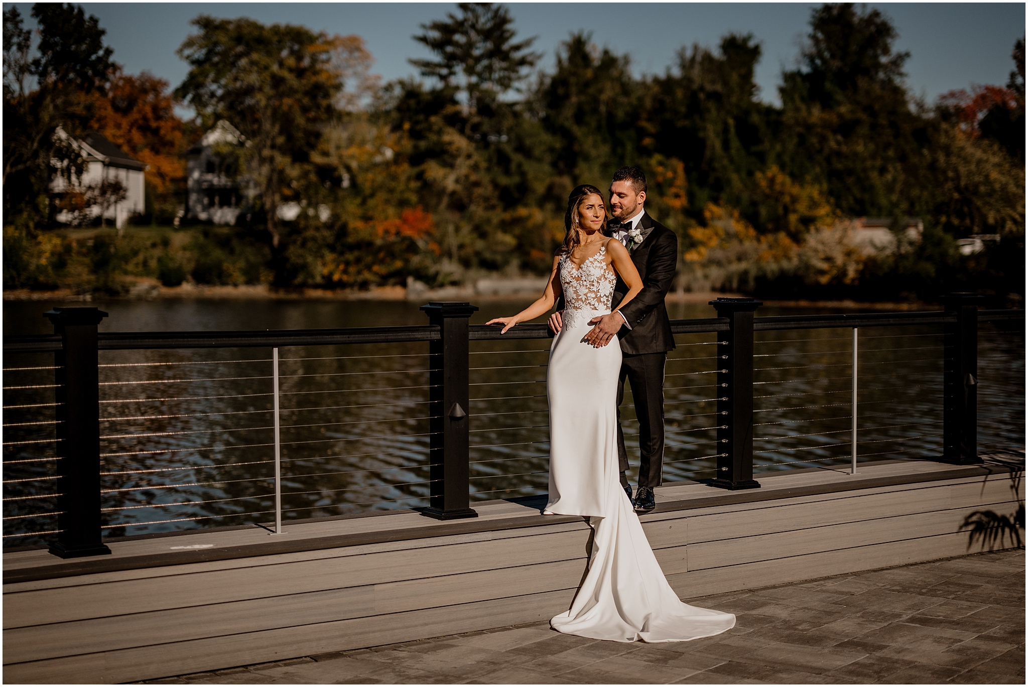 bride and groom hug on dock outside the Waters Edge at Centerport