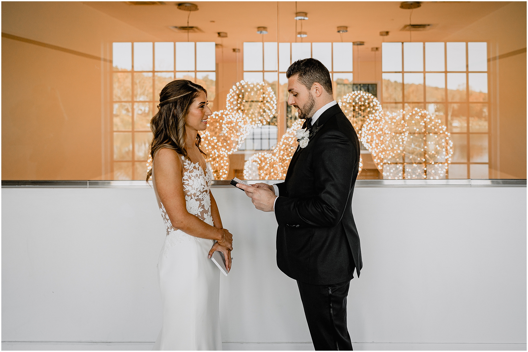 groom reads bride vows in lobby of the Waters Edge at Centerport