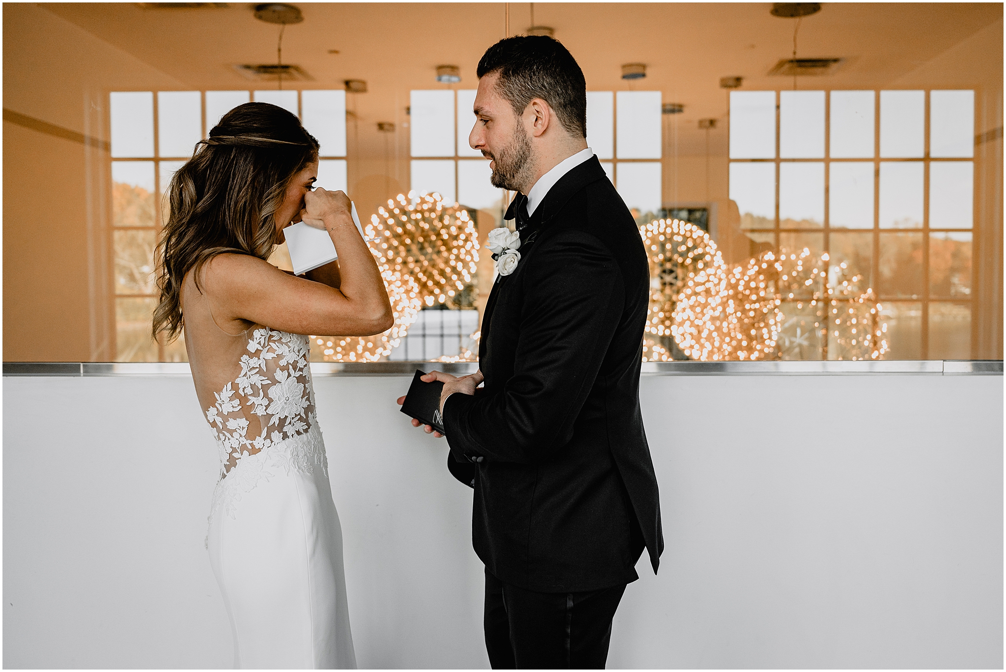 bride wipes tear from her eye during private vow exchange inside the Waters Edge at Centerport