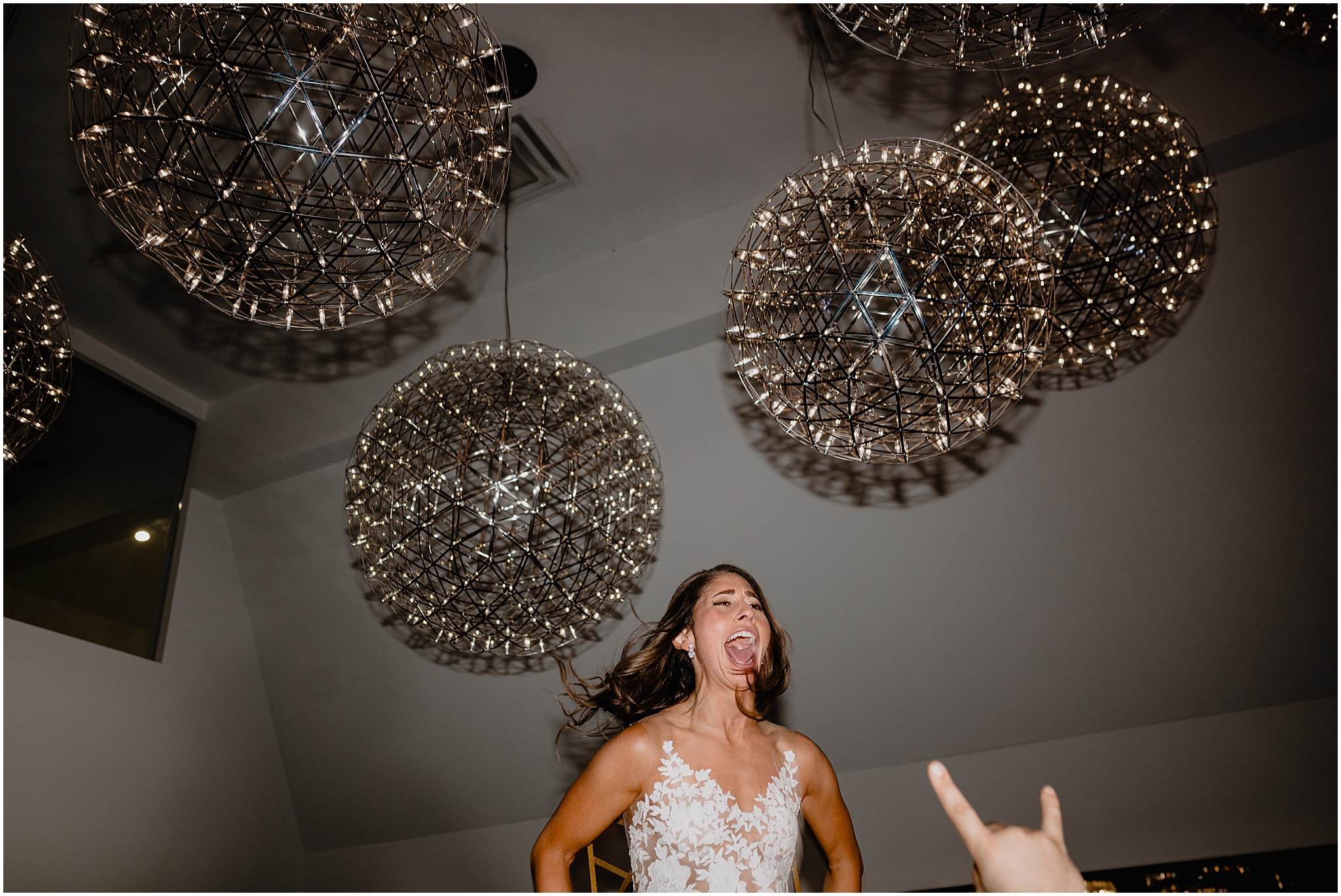 bride laughs while being lifted in the air during Long Island wedding reception