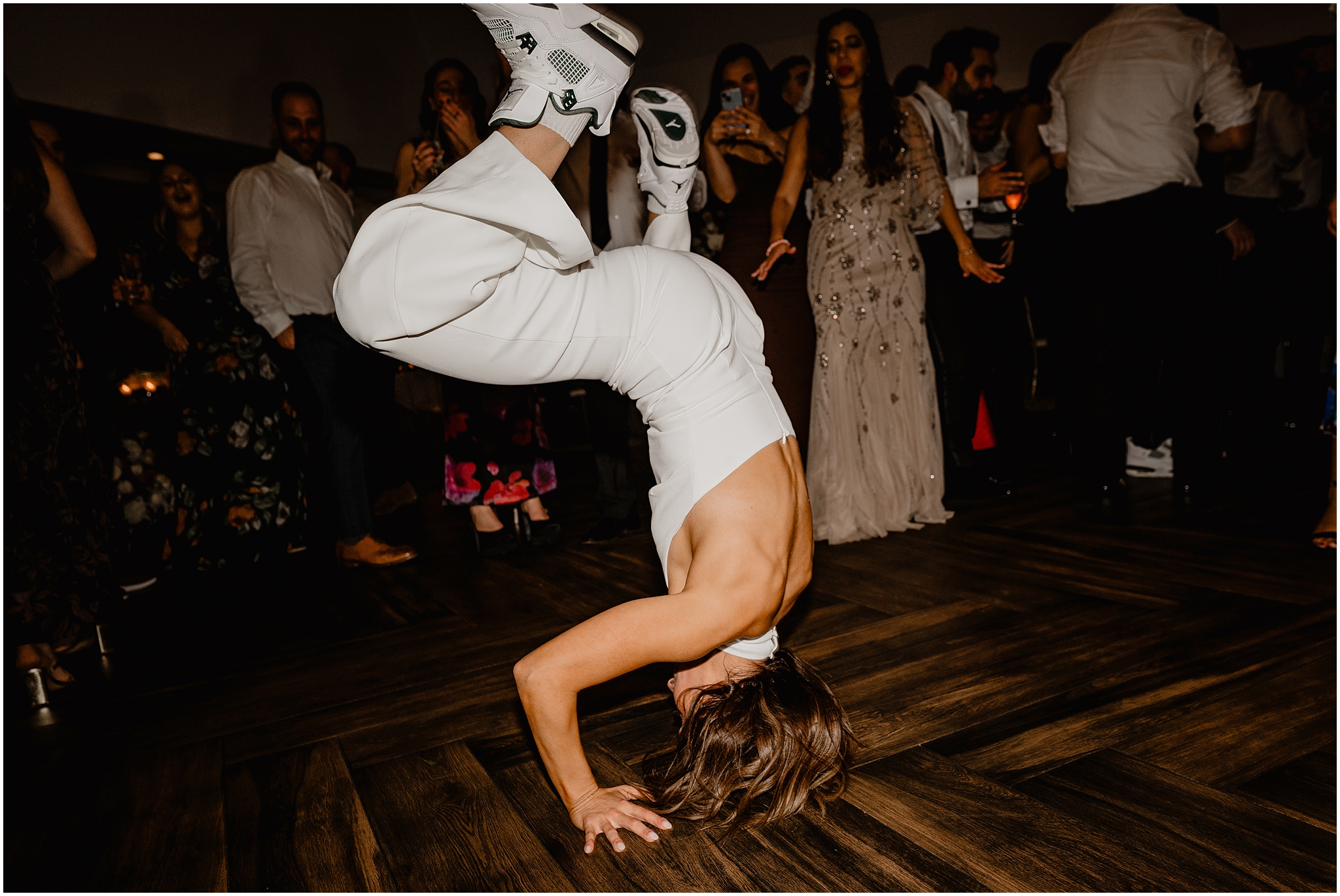 guest does hand stand on dance floor during Long Island wedding reception
