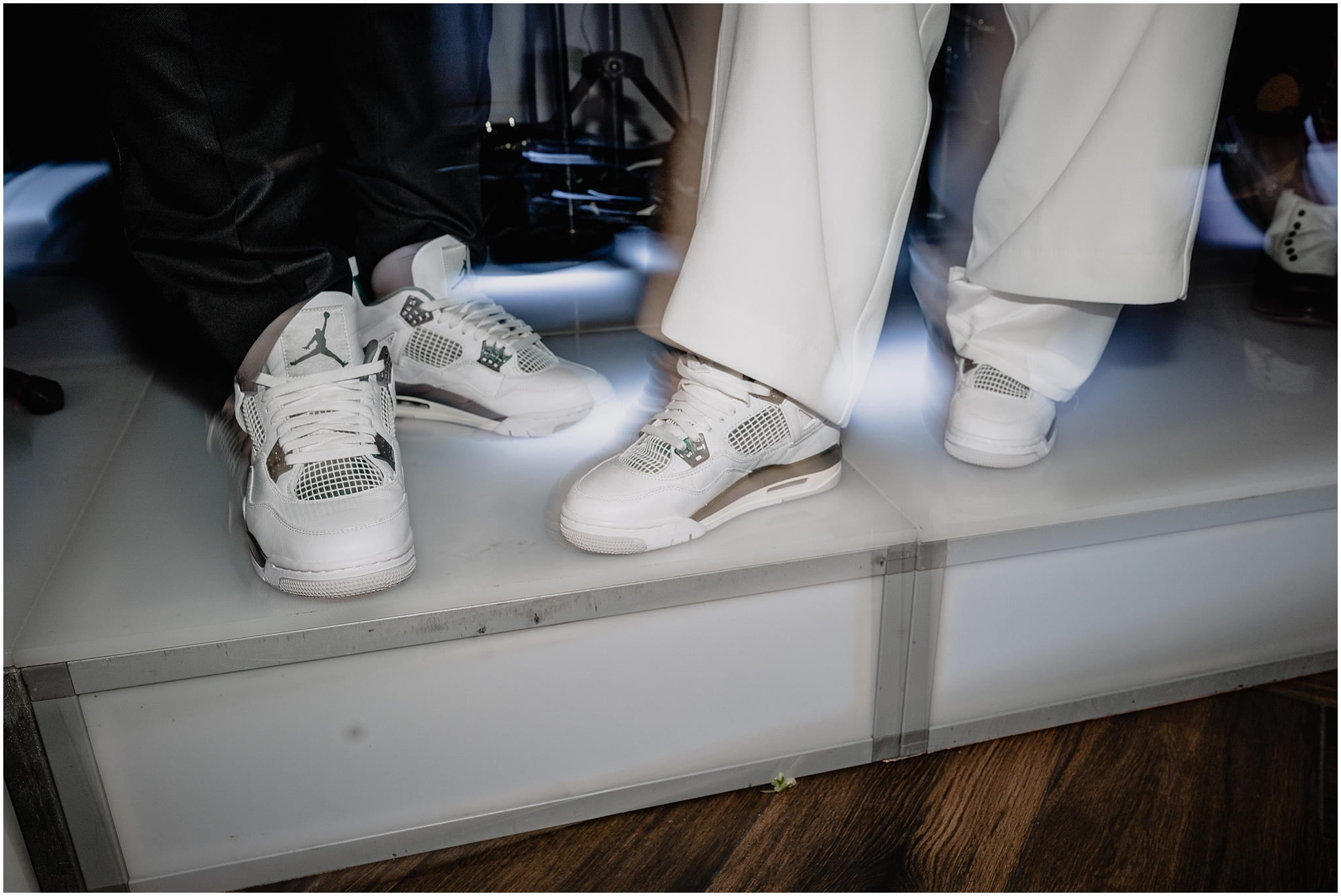 bride and groom show off custom sneakers on band's podium during Long Island wedding reception