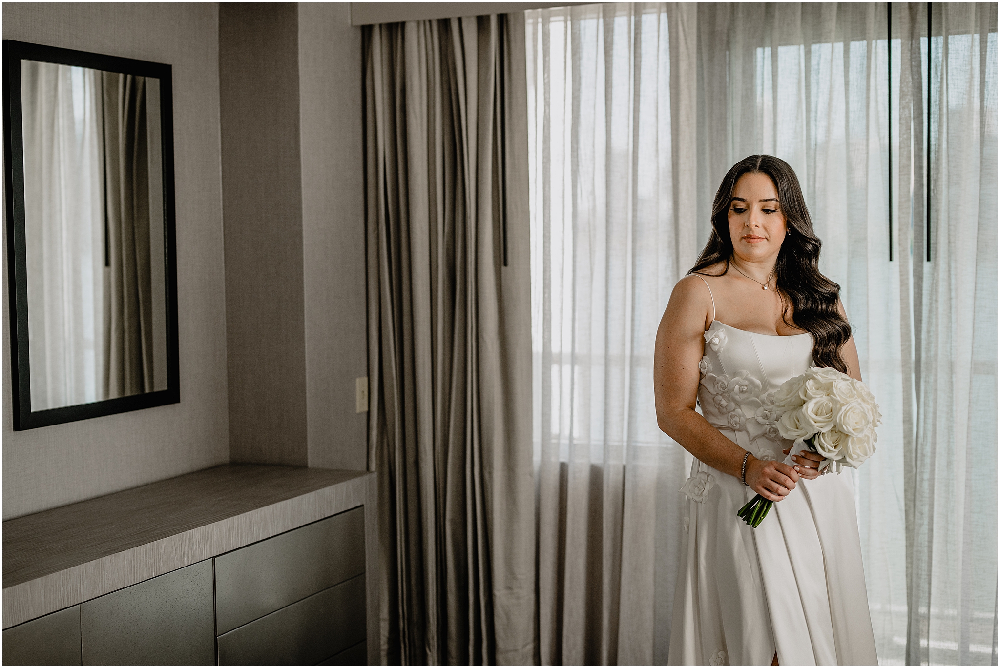 bride hold bouquet of white roses standing in Jersey City hotel