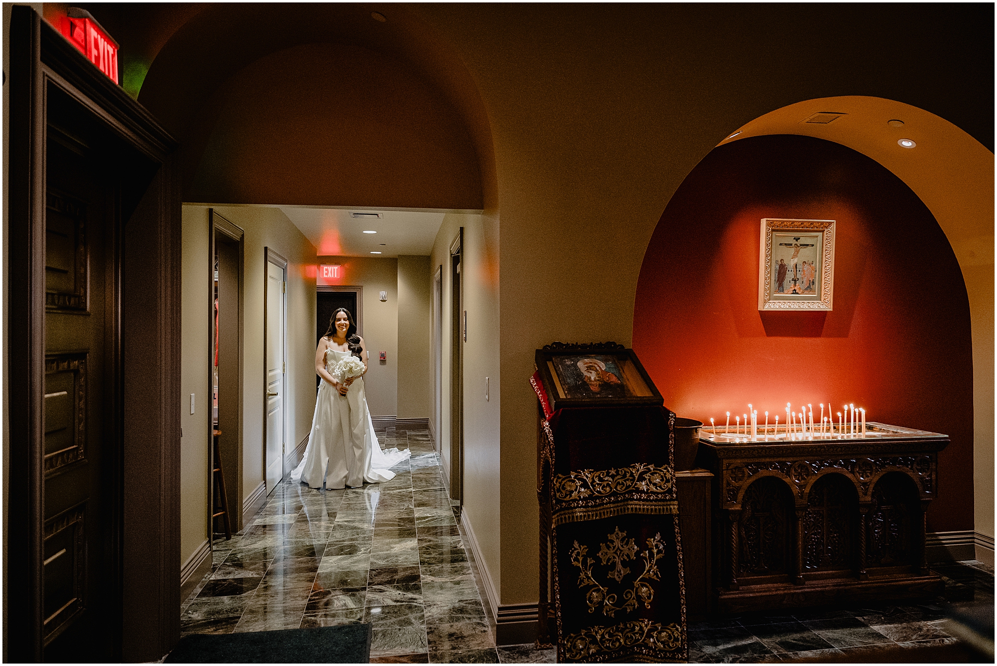 bride walks through lobby of New Jersey church holding bouquet of white roses 