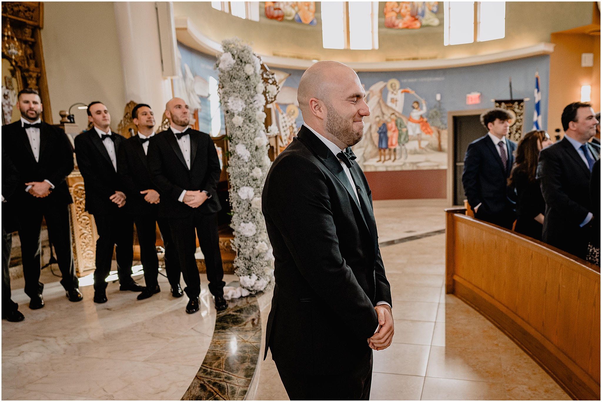 groom grins waiting for bride to talk down aisle during church wedding ceremony 