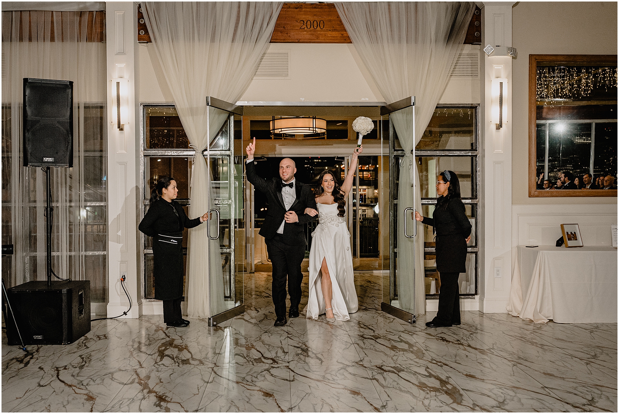 newlyweds cheer walking into wedding reception at the Liberty House Restaurant