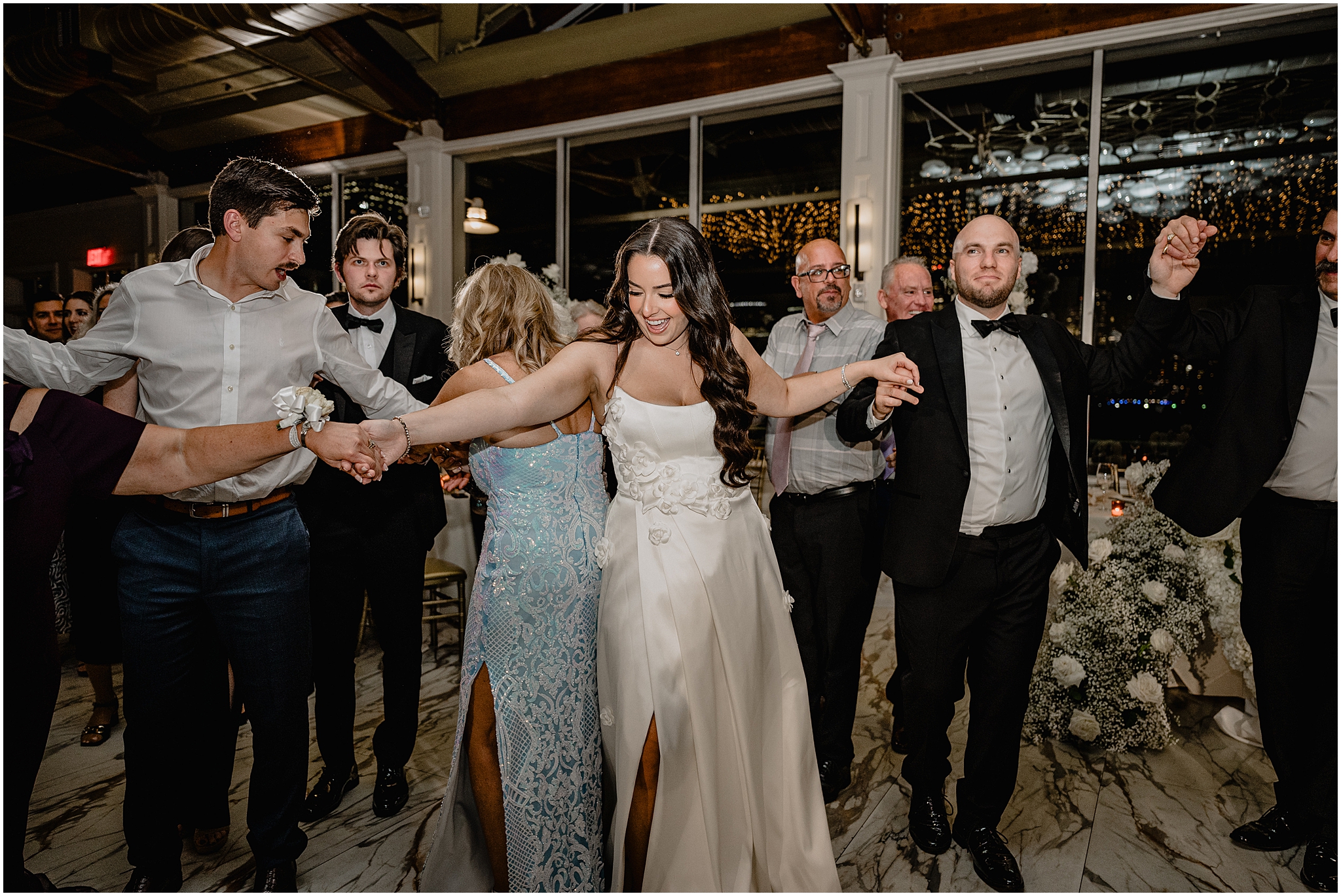 bride and groom dance in circle with guests holding hands at the Liberty House Restaurant