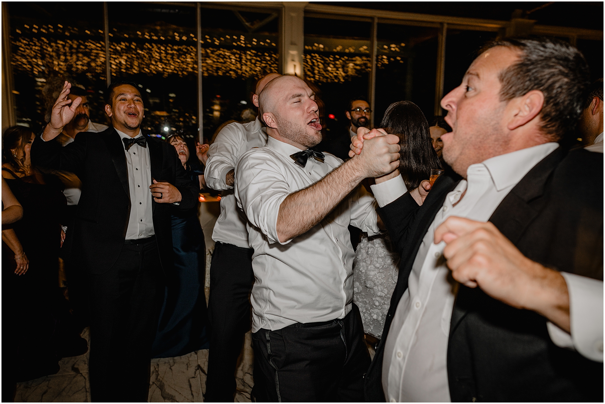 groom holds man's hand dancing at wedding reception at the Liberty House Restaurant