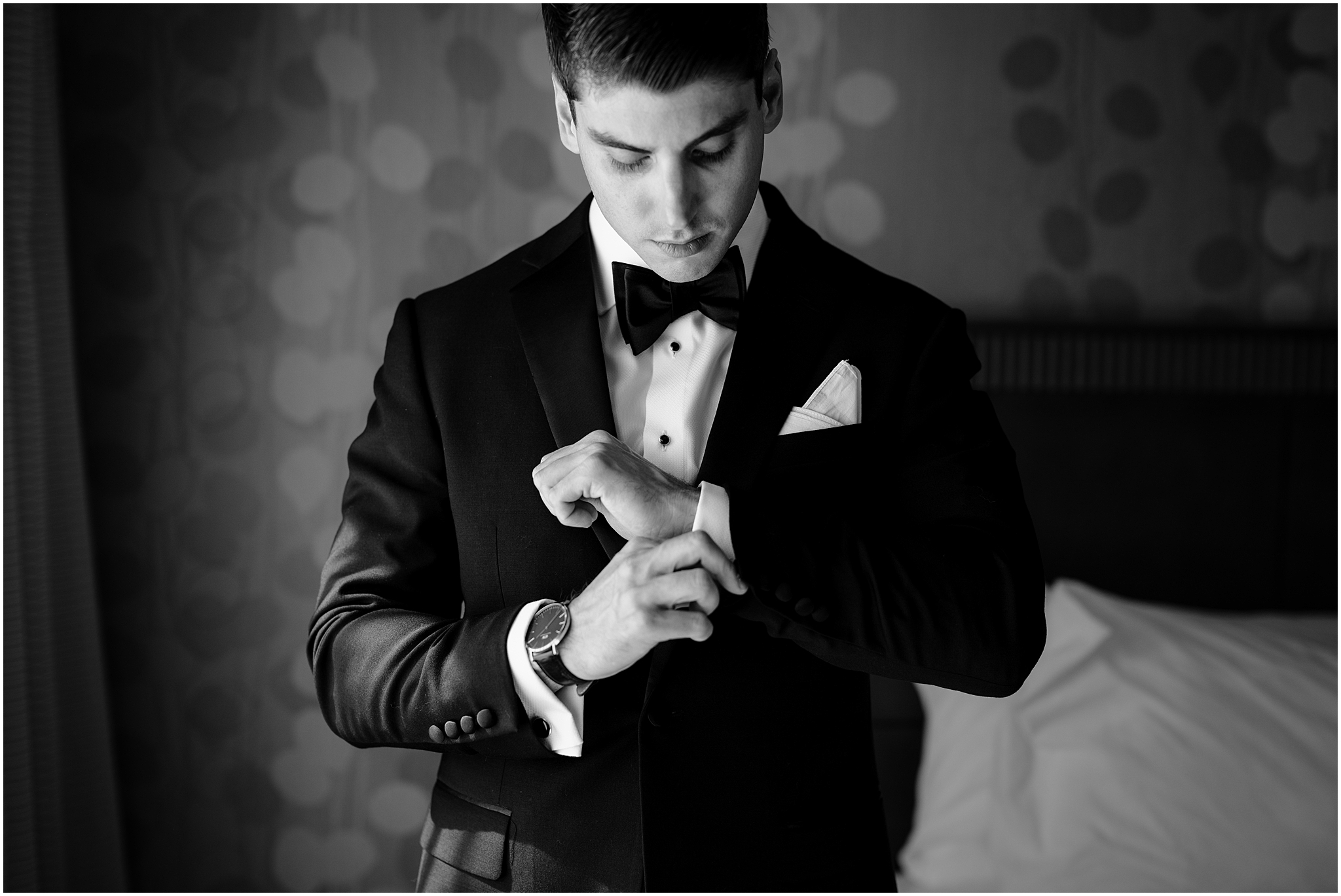 groom adjusts cufflinks of suit shirt in hotel before New Jersey wedding 