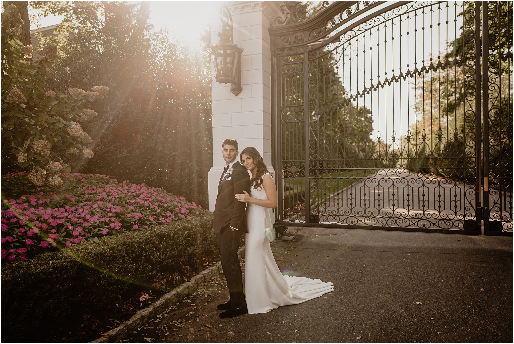 bride leans head on groom's shoulder outside The Shadowbrook at Shrewsbury by black gate 