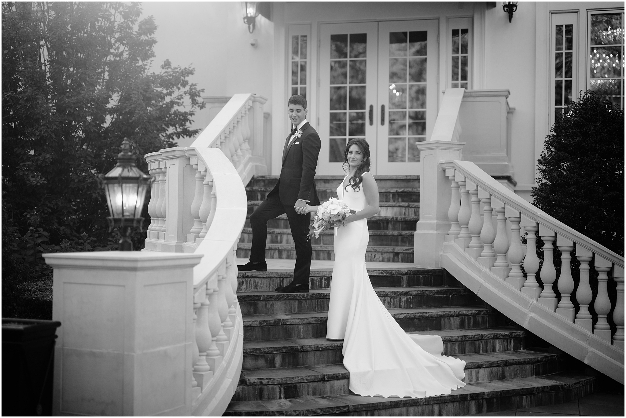 groom walks up steps leading bride on the back patio at The Shadowbrook at Shrewsbury