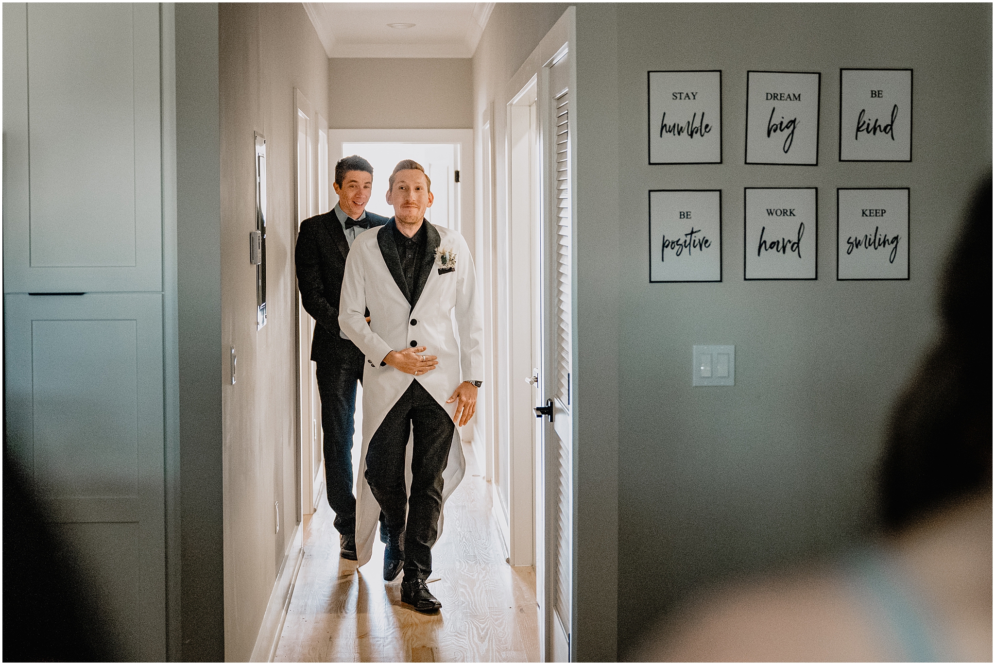 groom walks down hallway in white sun jacket and black shirt for Jersey City wedding