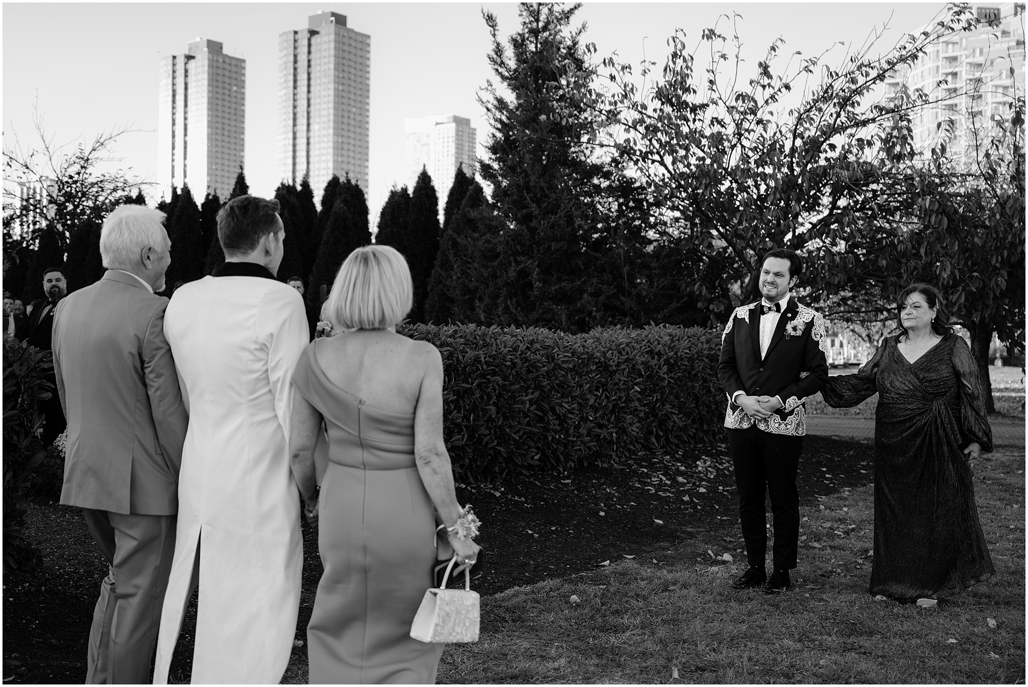 parents walk grooms to meet each other during wedding ceremony at the Liberty House in Jersey City