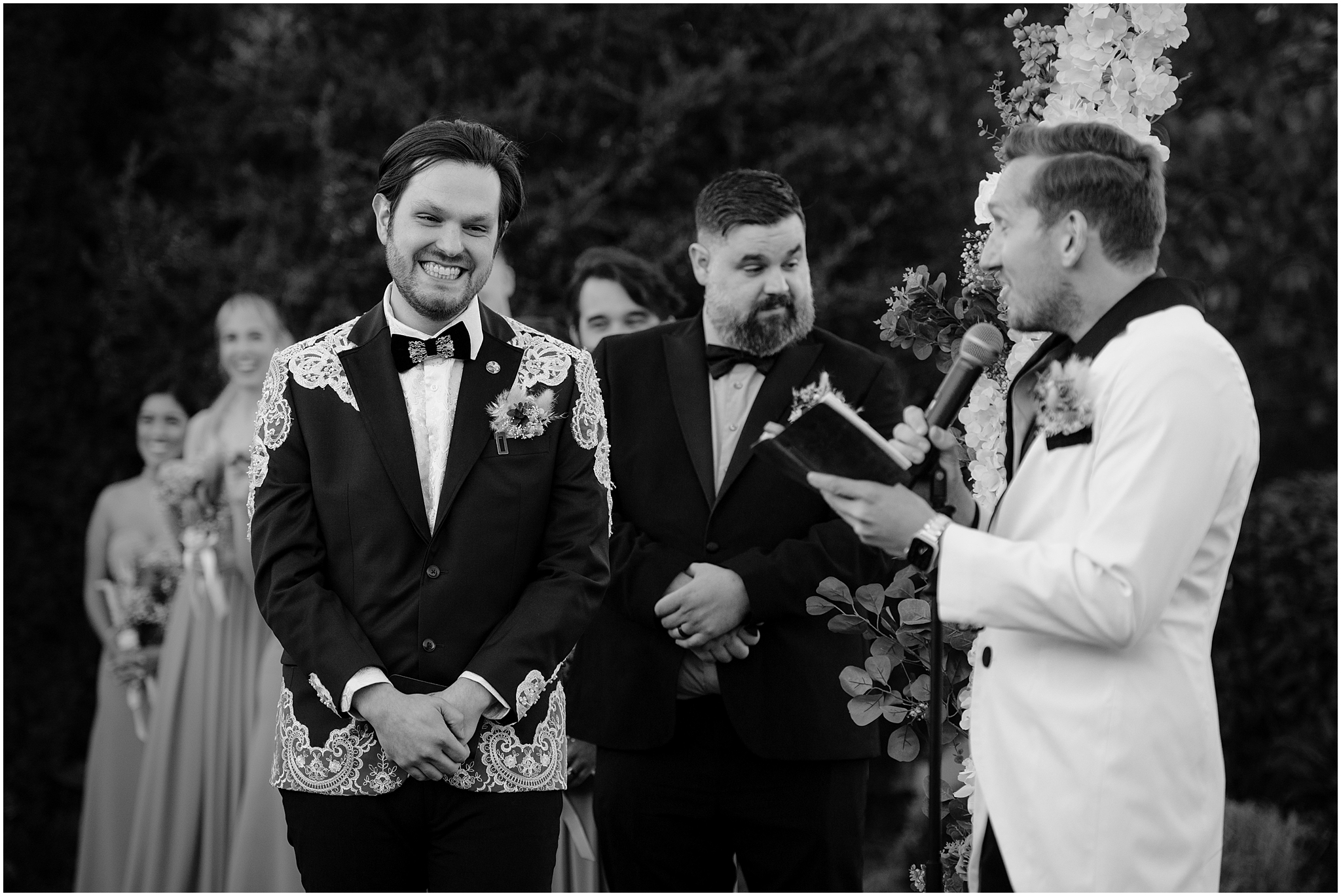 groom grins listening to vows during wedding ceremony at the Liberty House in Jersey City