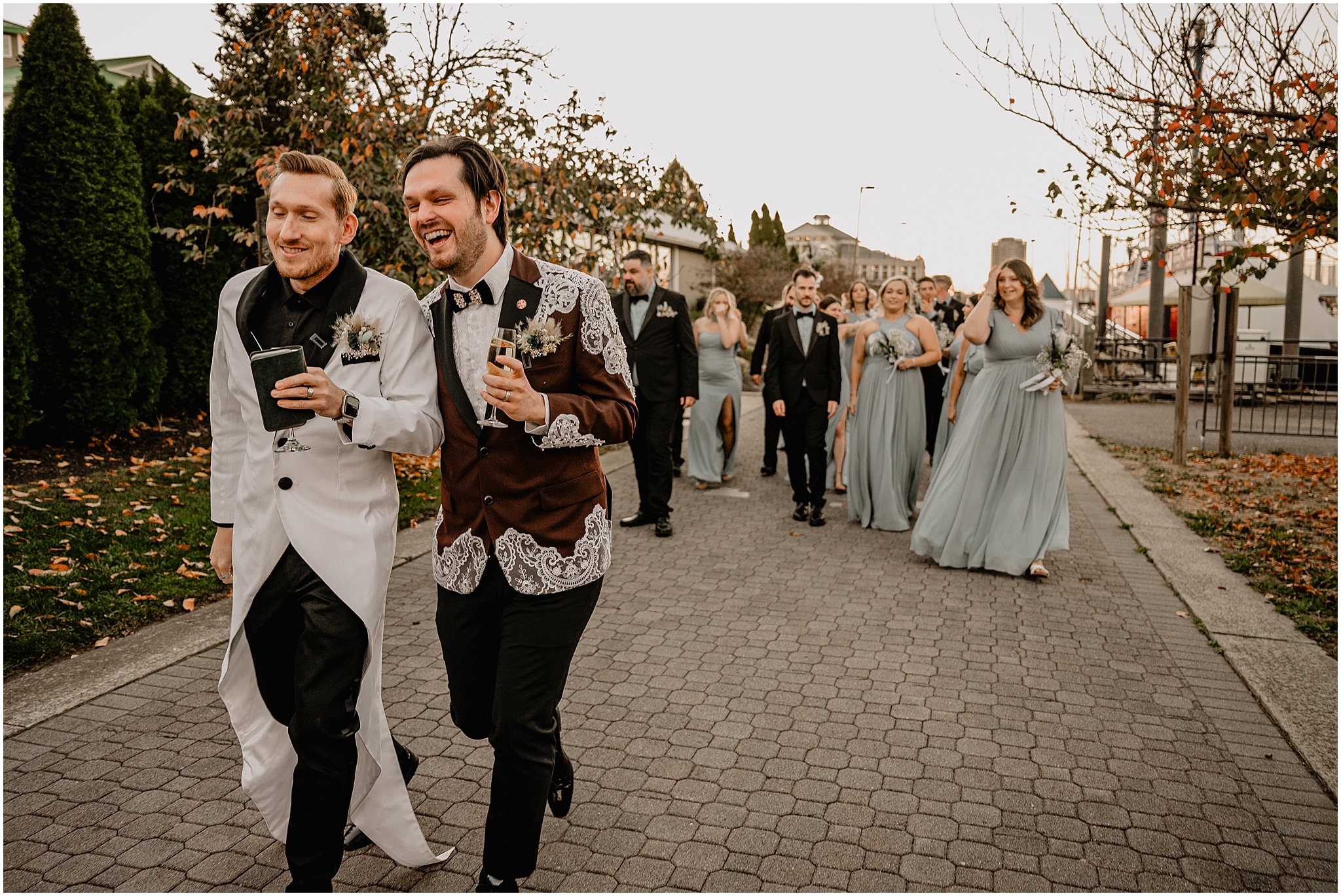 grooms walk with bridal party behind them outside the Liberty House in Jersey City