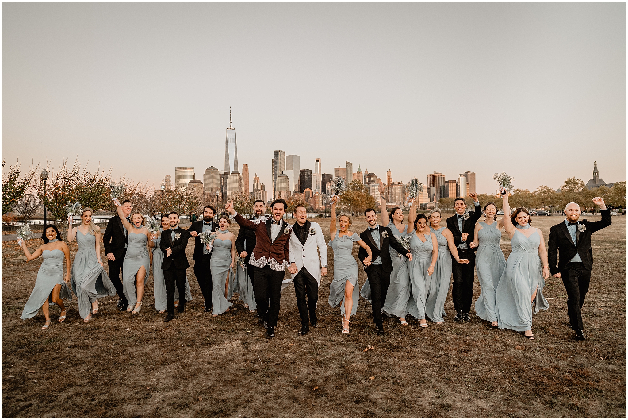 grooms walk with wedding party in light blue dresses and black suits 