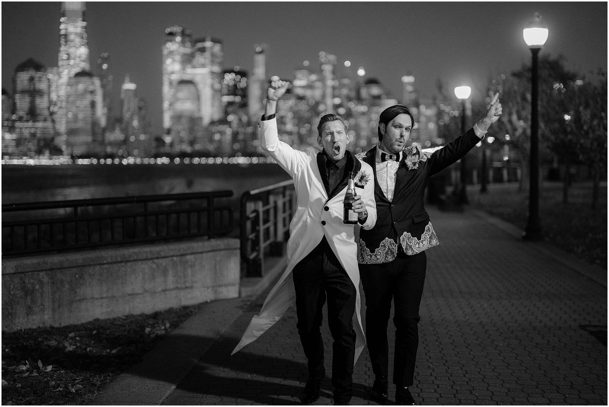 grooms cheer holding bottle of champagne and walking through Jersey City at night