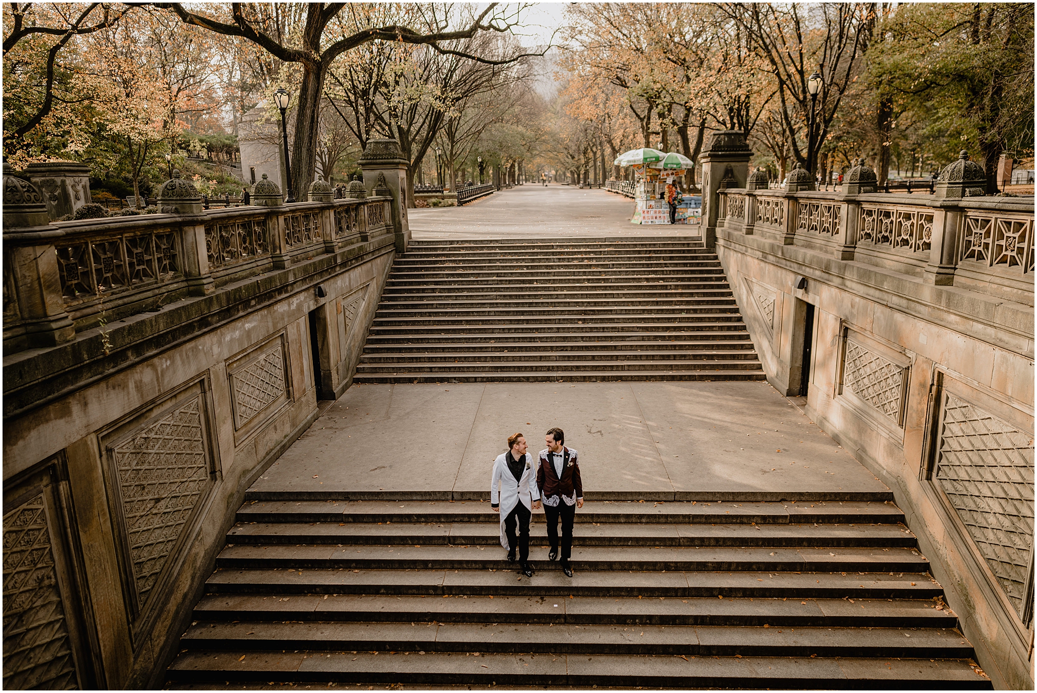 couple holds hands walking down steps inside Central Park 