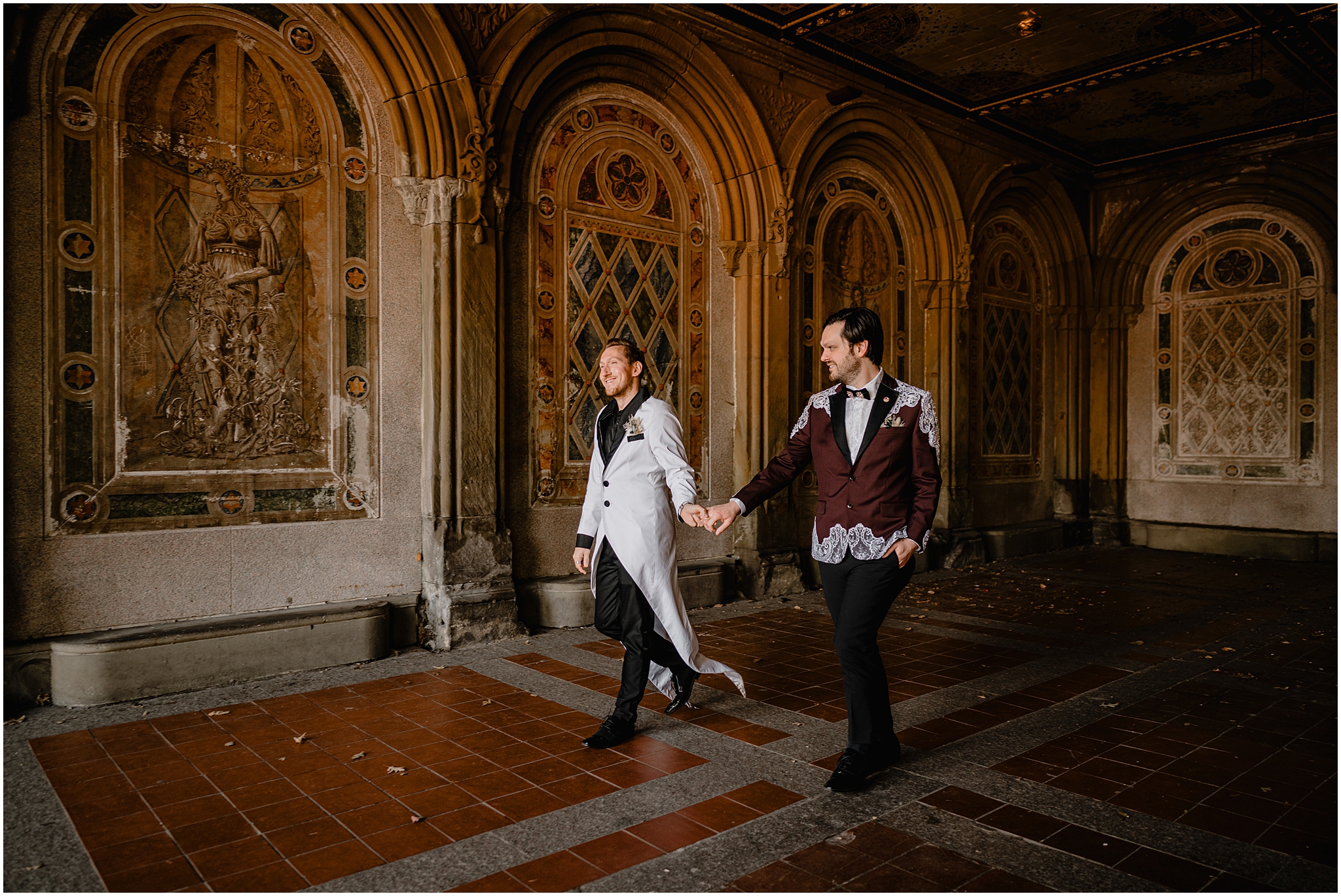 two grooms in custom suit jackets walk through Bethesda terrace 