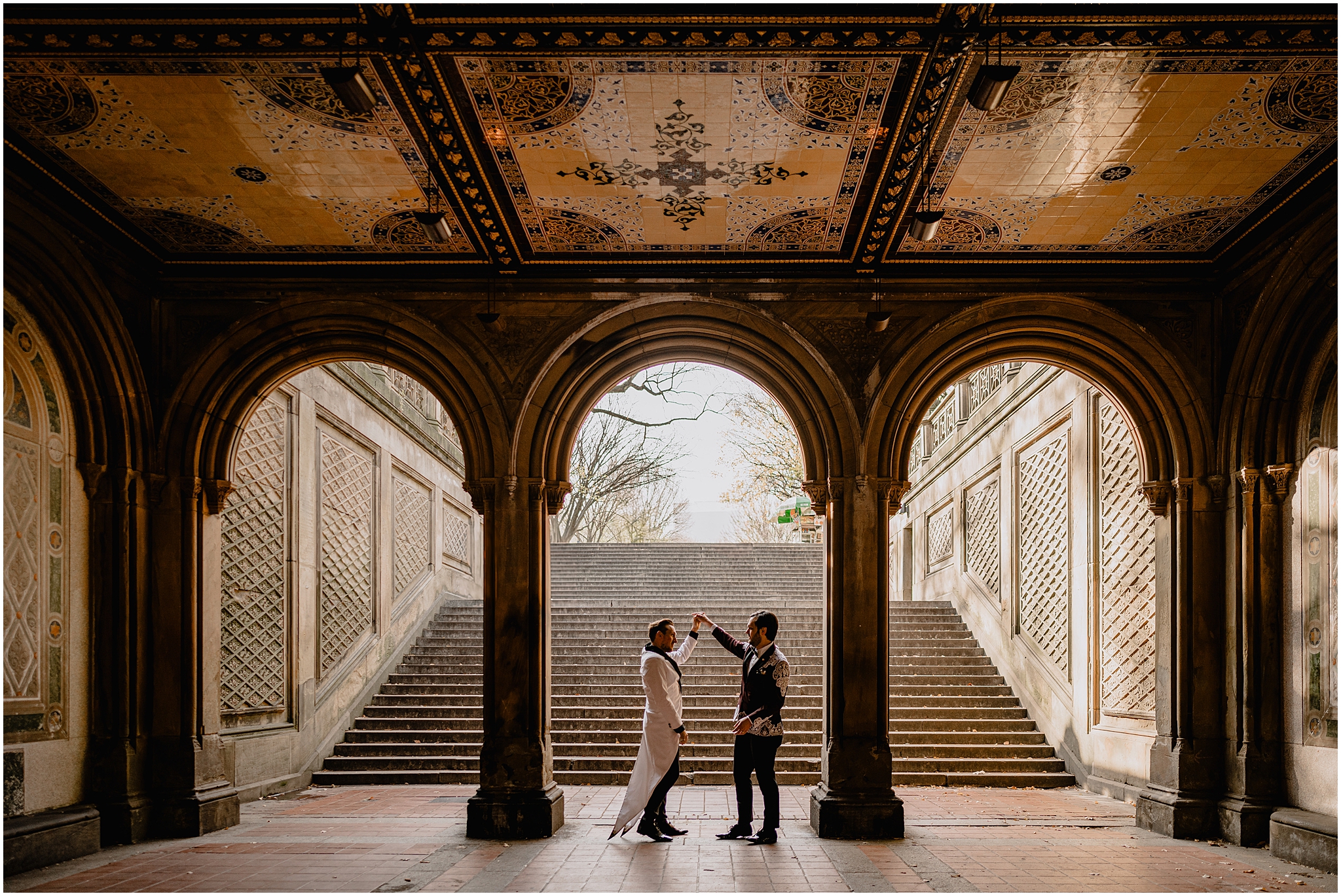 groom twirls partner under archway in NYC park