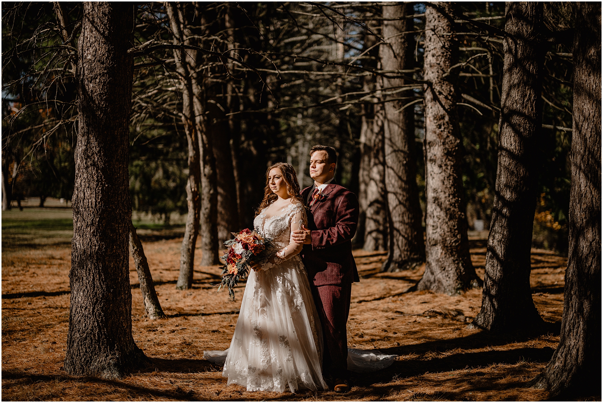 bride and groom hug between trees at the Barn at Perona Farms