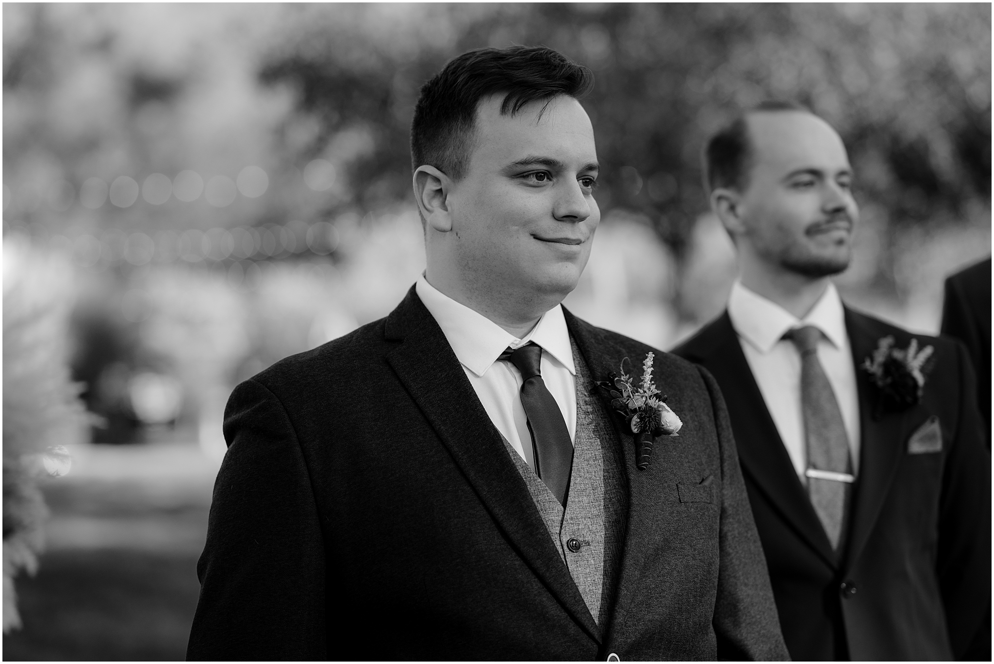 groom smiles watching bride during wedding ceremony at the Barn at Perona Farms