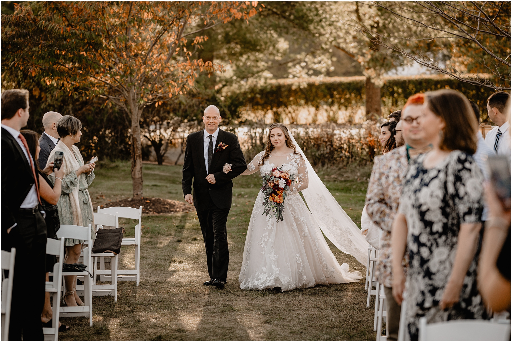 father escorts bride down the aisle for fall wedding ceremony at the Barn at Perona Farms
