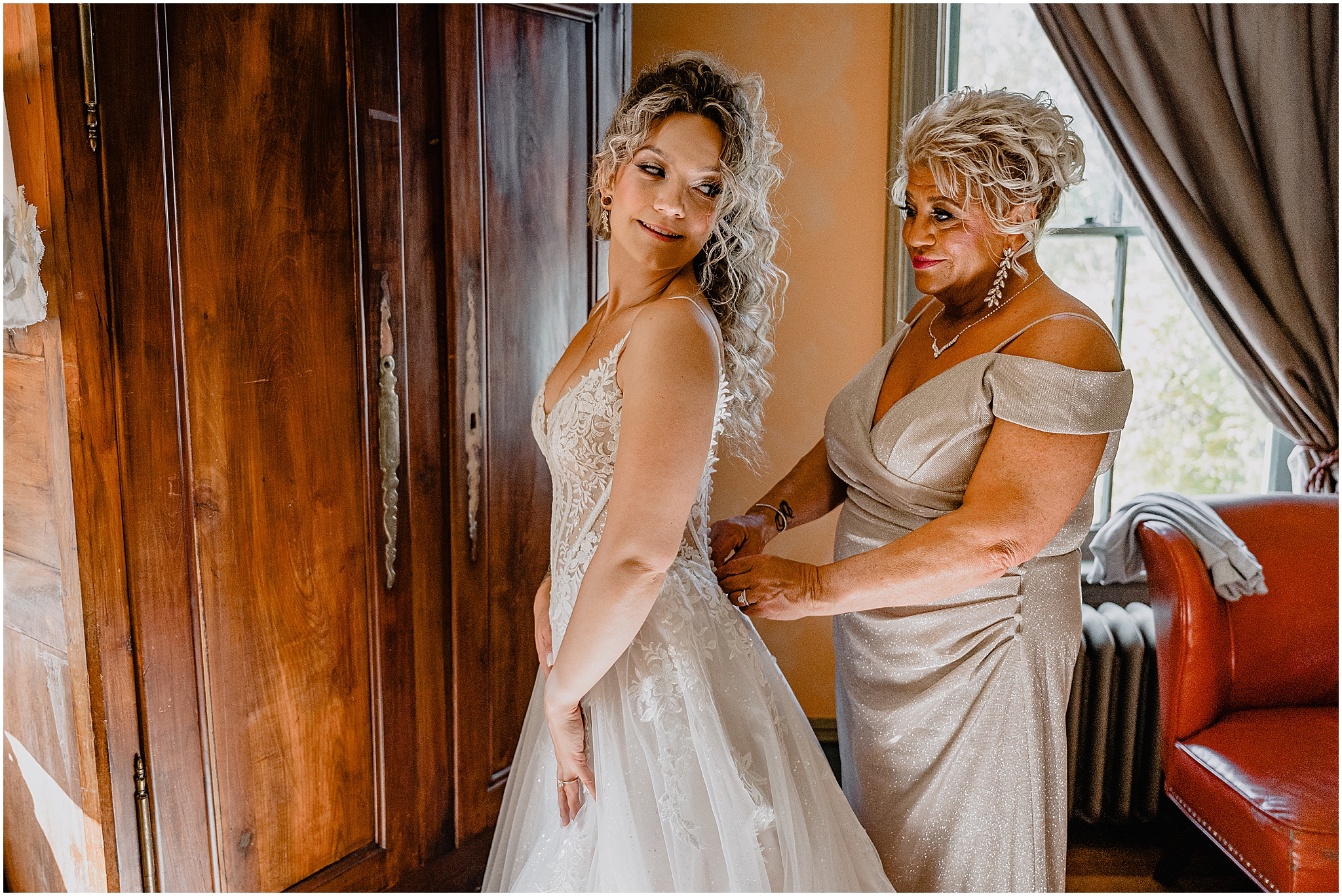 mother helps bride into wedding dress in suite at the Feast at Round Hill