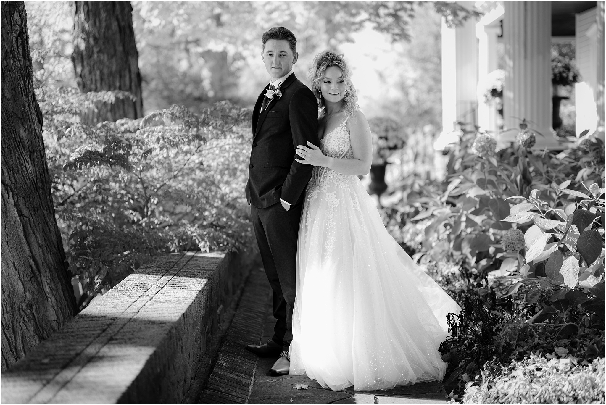 bride hugs groom from behind in the gardens of Hudson Valley wedding venue the Feast at Round Hill