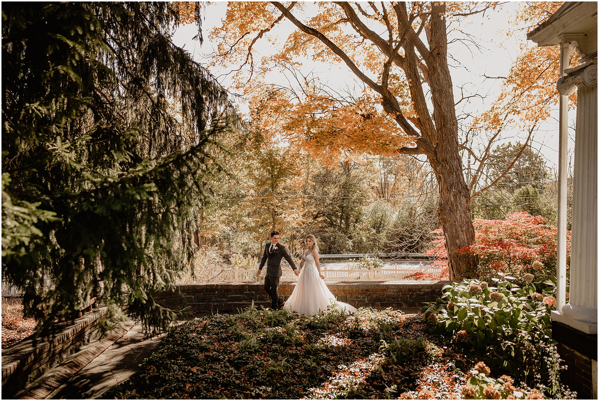 bride and groom hold hands walking through garden of Hudson Valley wedding venue the Feast at Round Hill