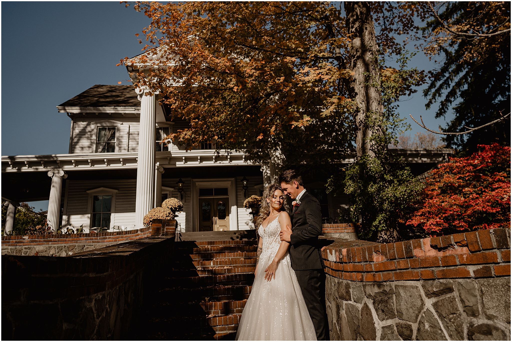 groom hugs bride from behind standing in front of the Feast at Round Hill
