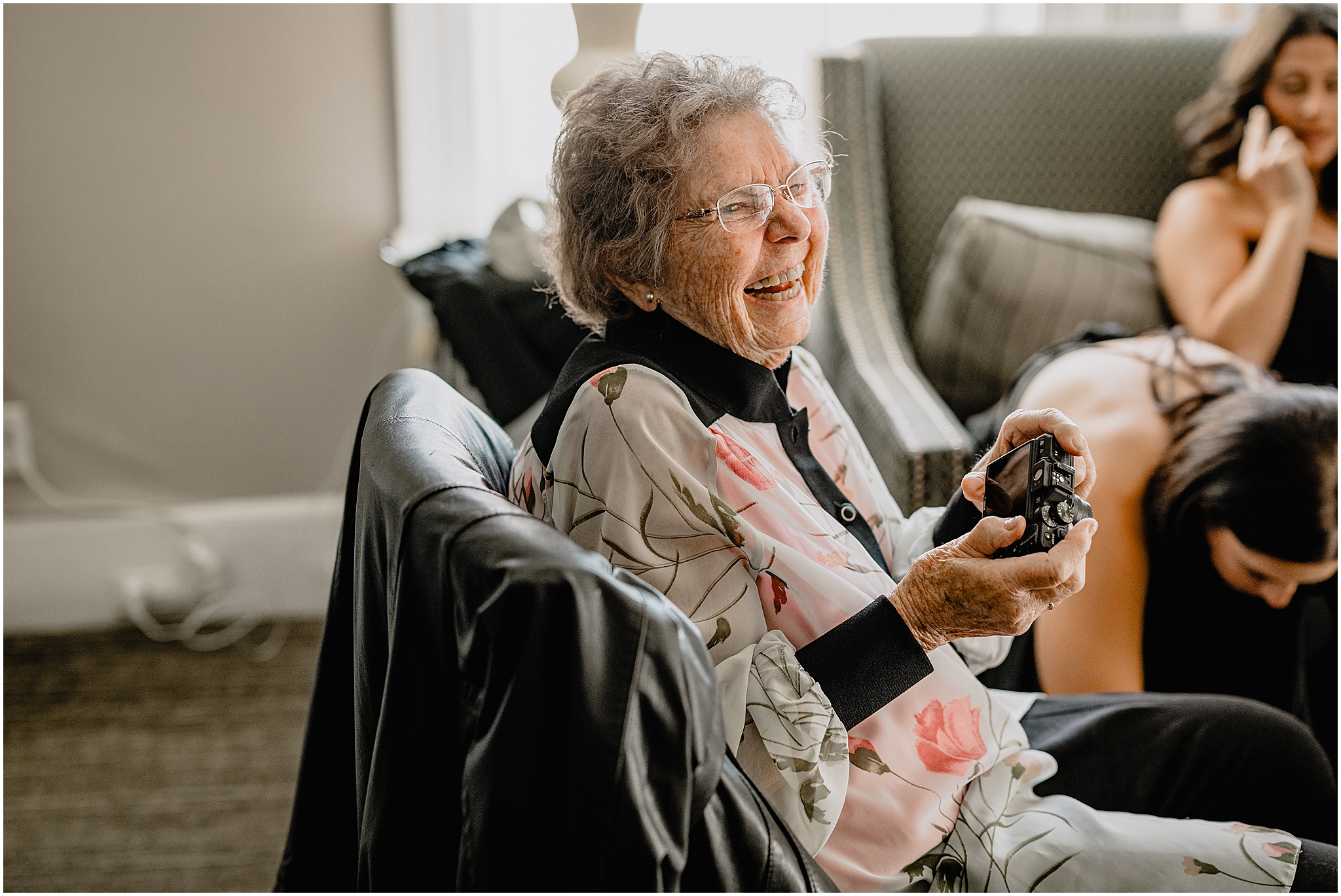 grandmother holds digital camera laughing during bridal prep at Tappan Hill Mansion
